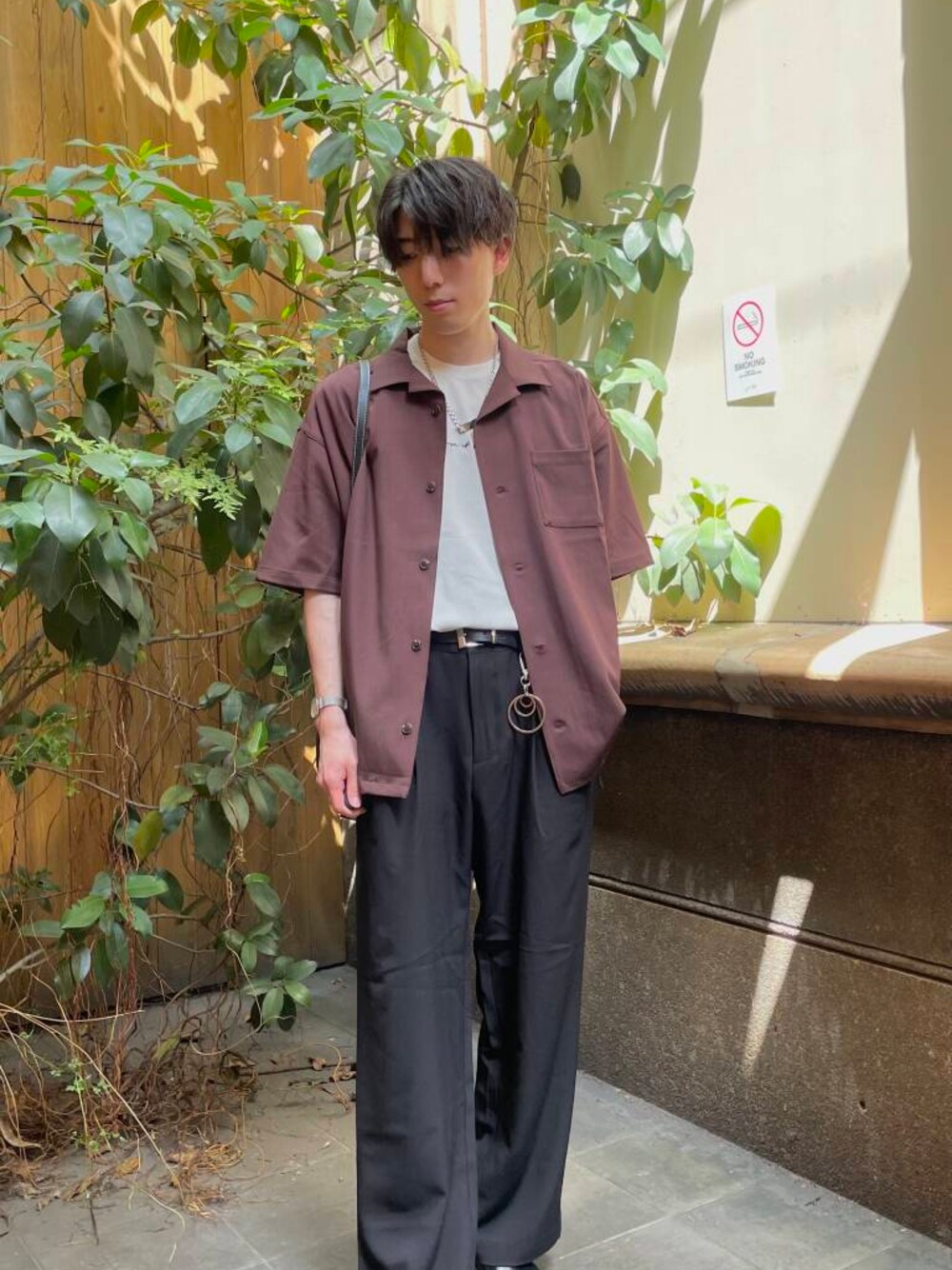 ブラック系のその他シューズ、ブラック系のスラックス、ホワイト系のTシャツ/カットソーを着用したメンズの夏コーディネートの1枚目の写真