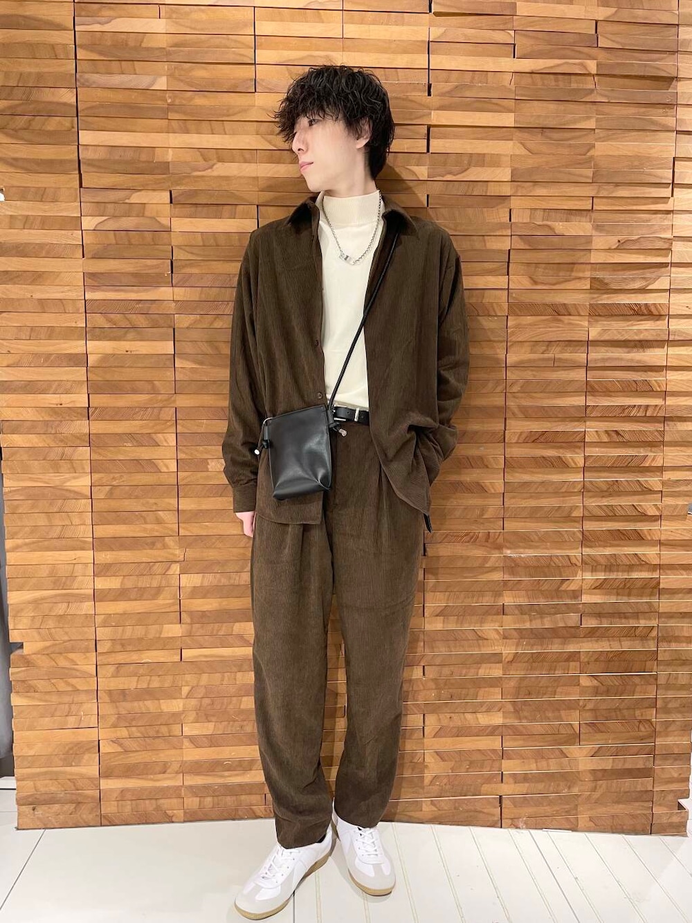 ホワイト系のスニーカー、ブラック系のショルダーバッグ、ホワイト系のニット/セーターを着用したメンズの秋コーディネートの1枚目の写真