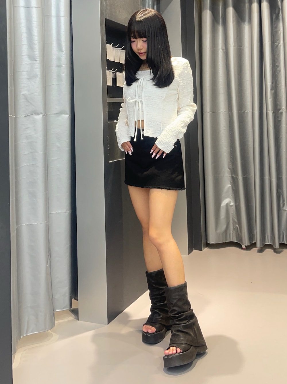 ホワイト系のTシャツ/カットソー、ブラック系のサンダル、ブラック系のスカートを着用したレディースの春コーディネートの1枚目の写真