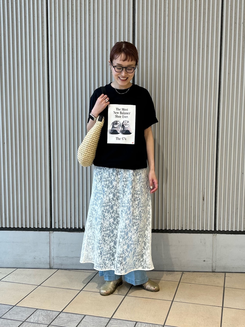ブラック系のTシャツ/カットソー、ホワイト系のワンピース、ブルー系のデニムパンツを着用したレディースの春コーディネートの1枚目の写真