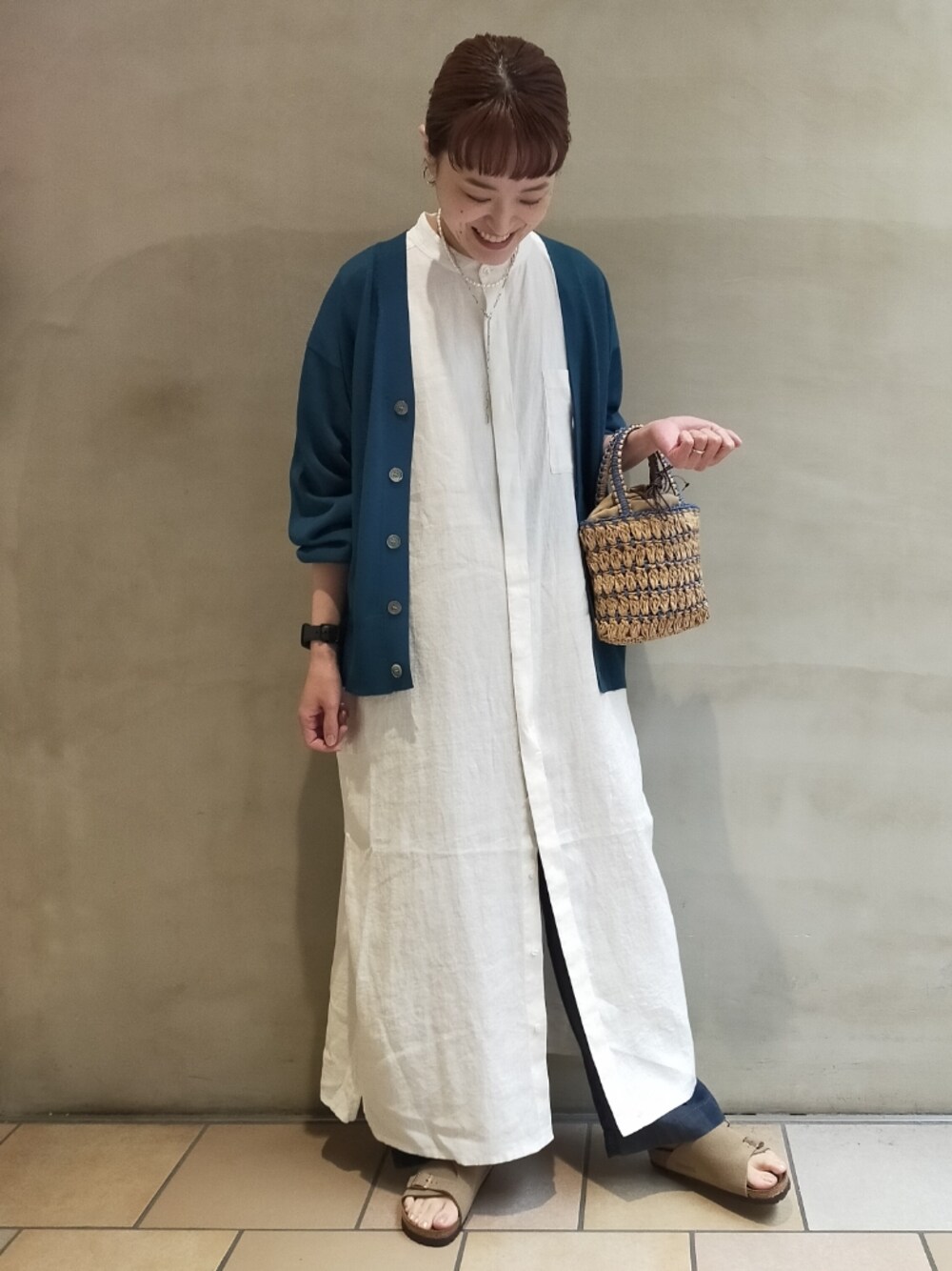 ブルー系のカーディガン/ボレロ、ホワイト系のワンピース、ブルー系のハンドバッグを着用したレディースの夏コーディネートの1枚目の写真