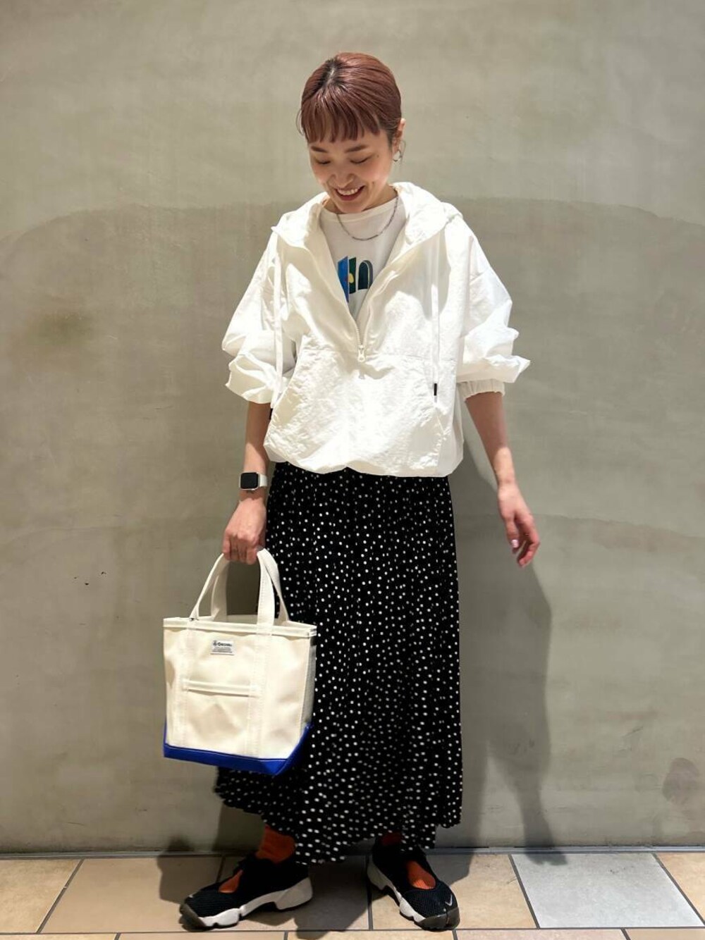 ホワイト系のパーカー、ブラック系のスカート、ホワイト系のTシャツ/カットソーを着用したレディースの春コーディネートの1枚目の写真