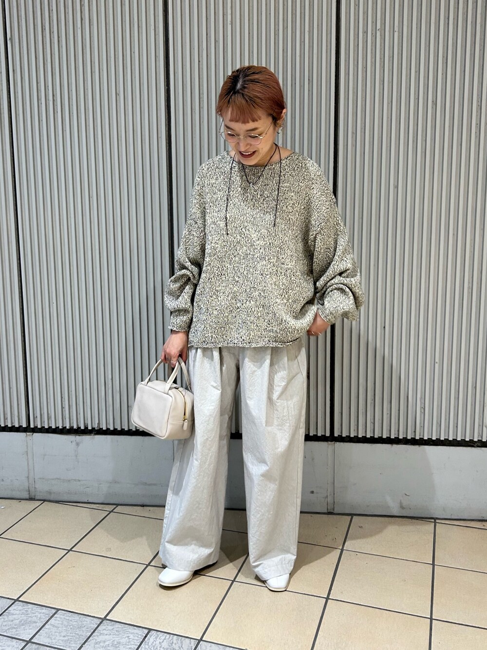 ベージュ系のニット/セーター、グレー系のその他パンツ、ホワイト系のブーツを着用したレディースの秋コーディネートの1枚目の写真