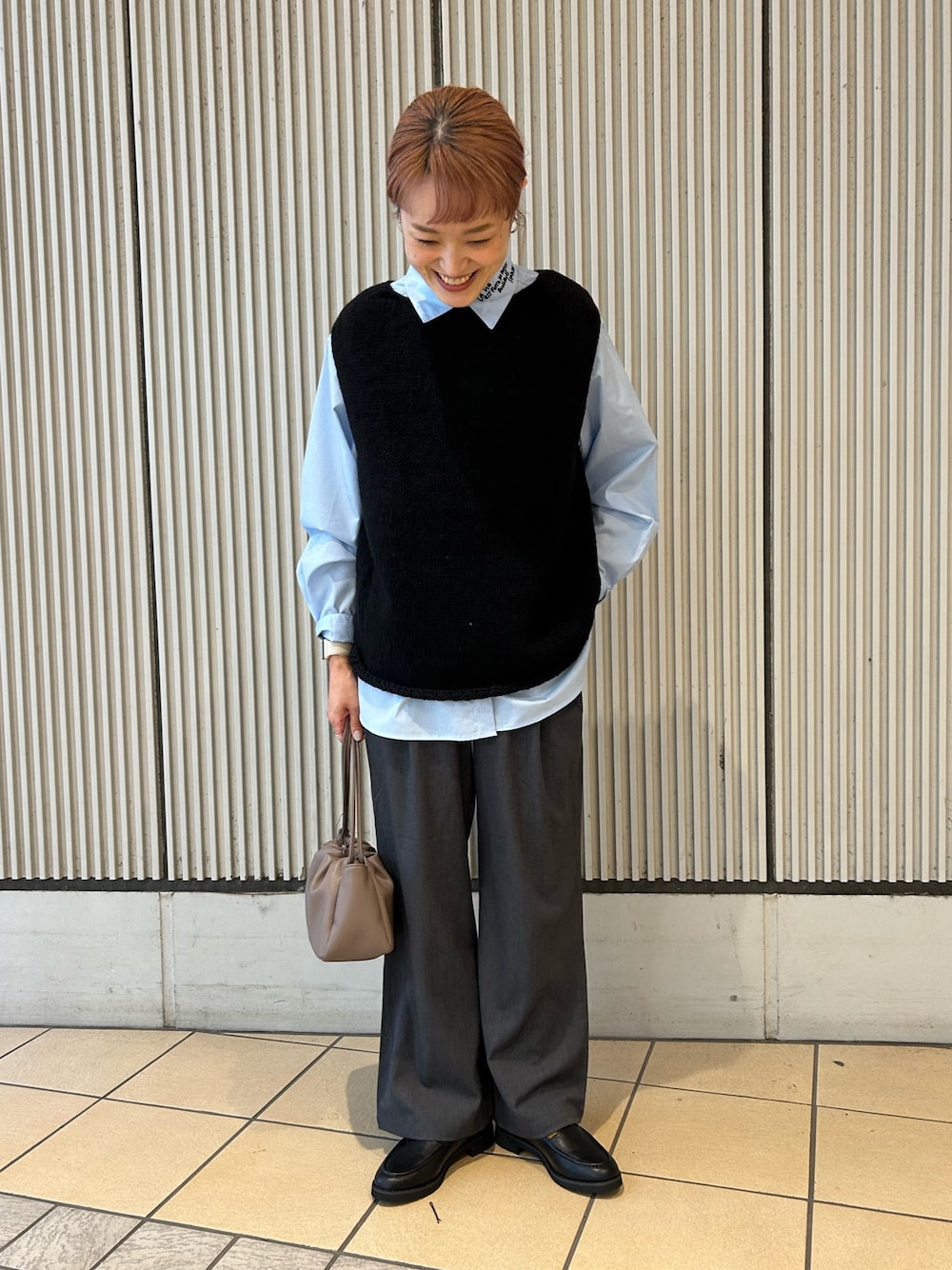 ブラック系のニット/セーター、ブルー系のシャツ/ブラウス、グレー系のその他パンツを着用したレディースの秋コーディネートの1枚目の写真