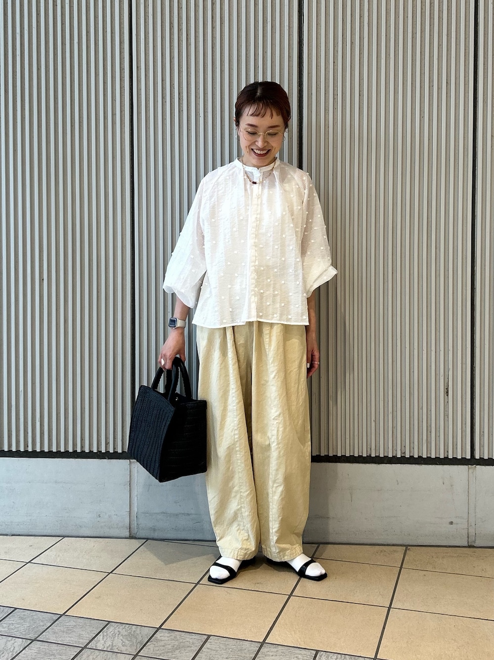ホワイト系のシャツ/ブラウス、イエロー系のその他パンツ、ブラック系のサンダルを着用したレディースの春コーディネートの1枚目の写真