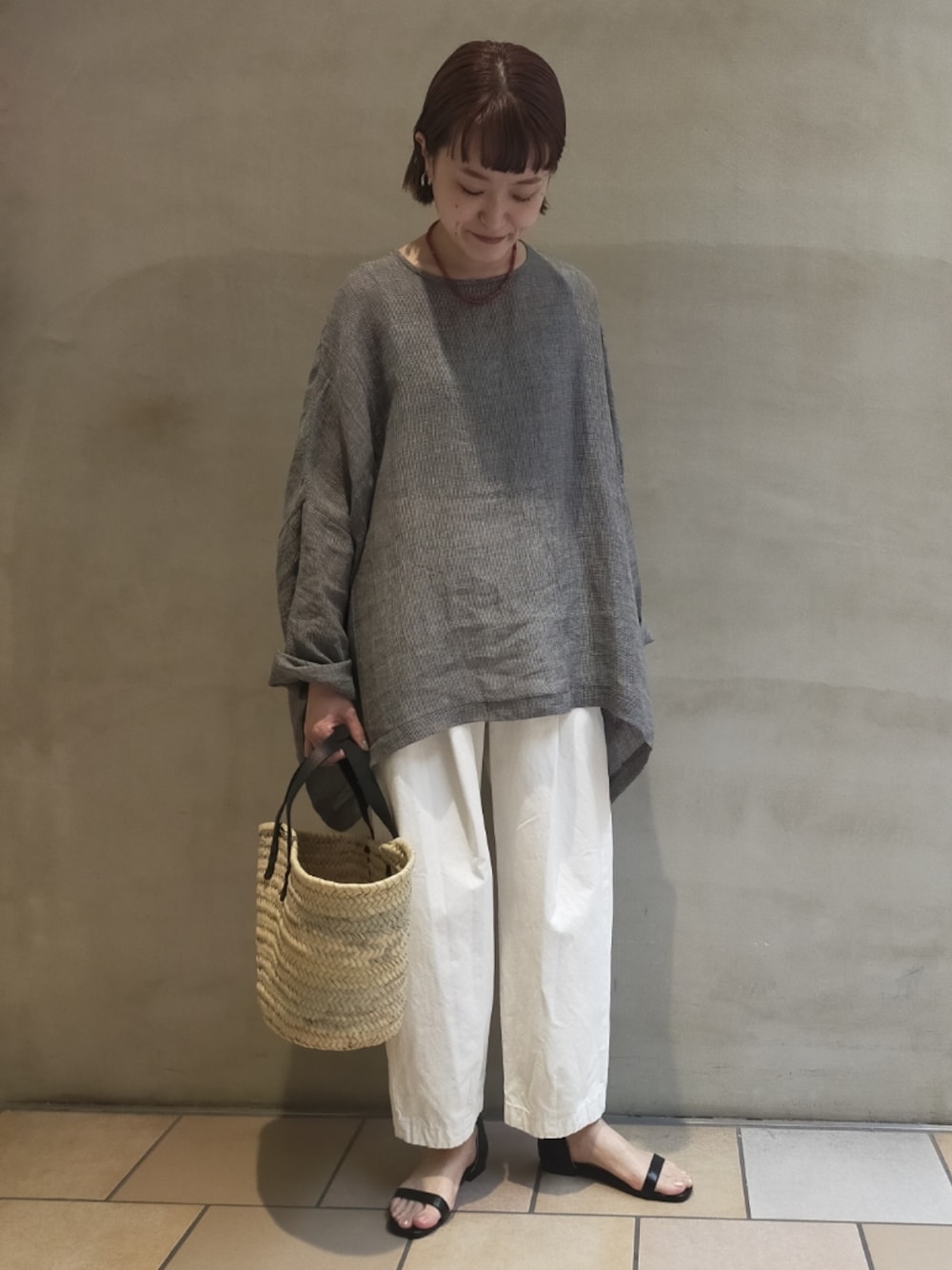 グレー系のシャツ/ブラウス、ホワイト系のその他パンツ、ブラック系のかごバッグを着用したレディースの春コーディネートの1枚目の写真