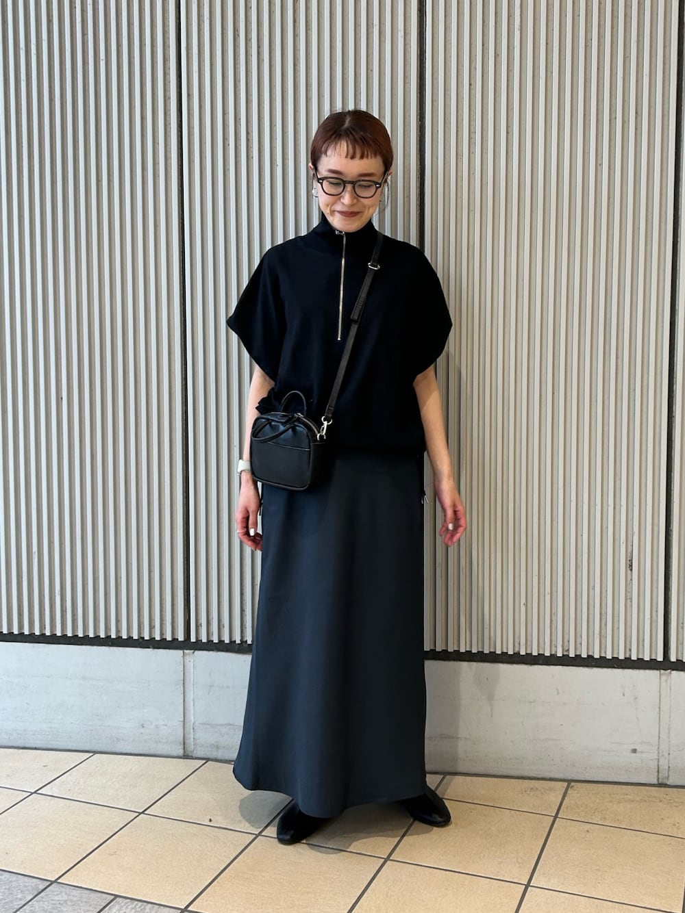 ブラック系のその他トップス、ブルー系のスカート、ブラック系のショルダーバッグを着用したレディースの春コーディネートの1枚目の写真
