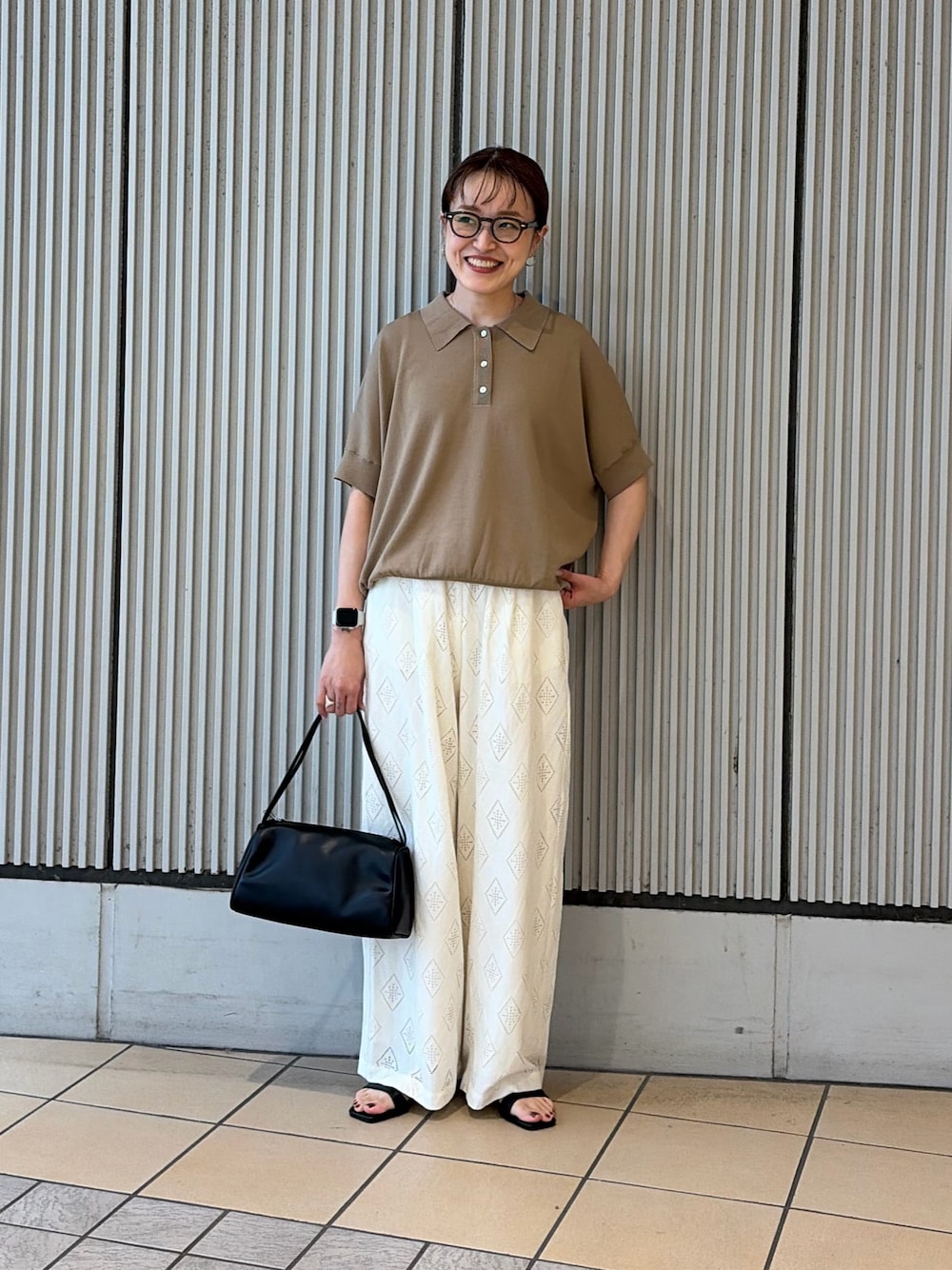 ベージュ系のニット/セーター、ホワイト系のその他パンツ、ブラック系のサンダルを着用したレディースの夏コーディネートの1枚目の写真