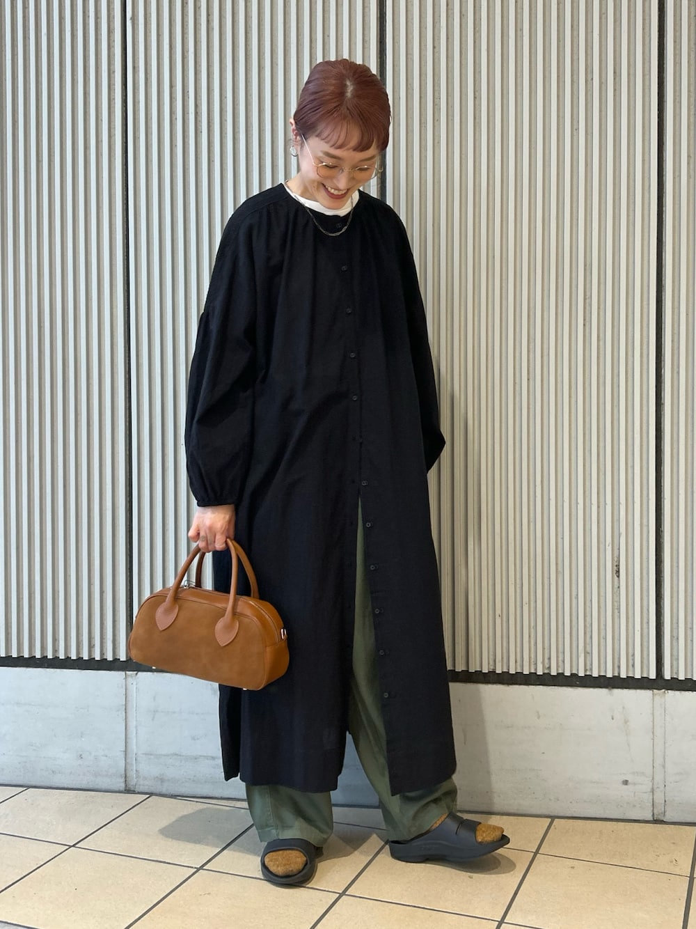 ブラック系のワンピース、グリーン系のその他パンツ、ブラウン系のショルダーバッグを着用したレディースの秋コーディネートの1枚目の写真