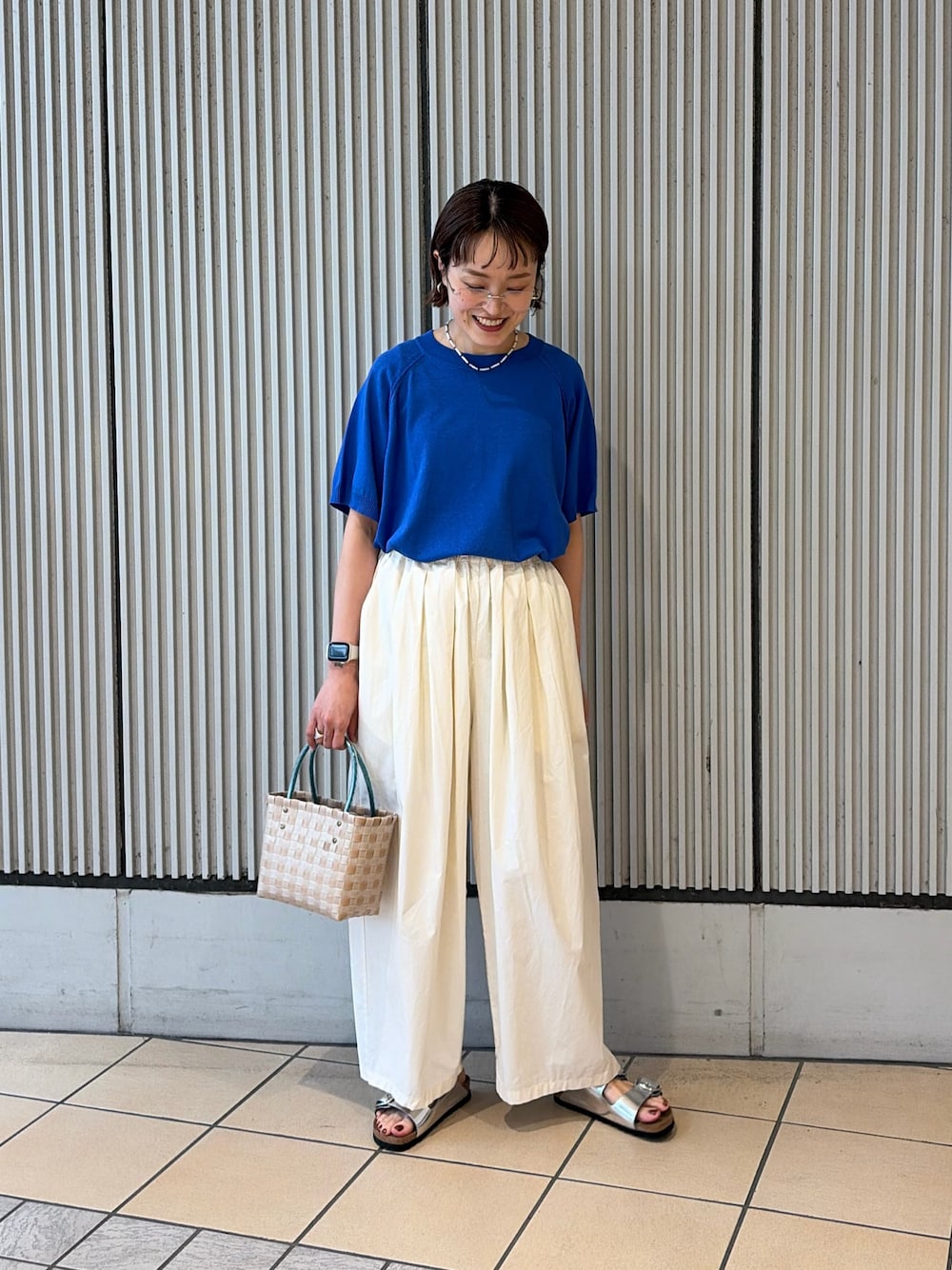 ブルー系のニット/セーター、ホワイト系のその他パンツ、シルバー系のサンダルを着用したレディースの夏コーディネートの1枚目の写真
