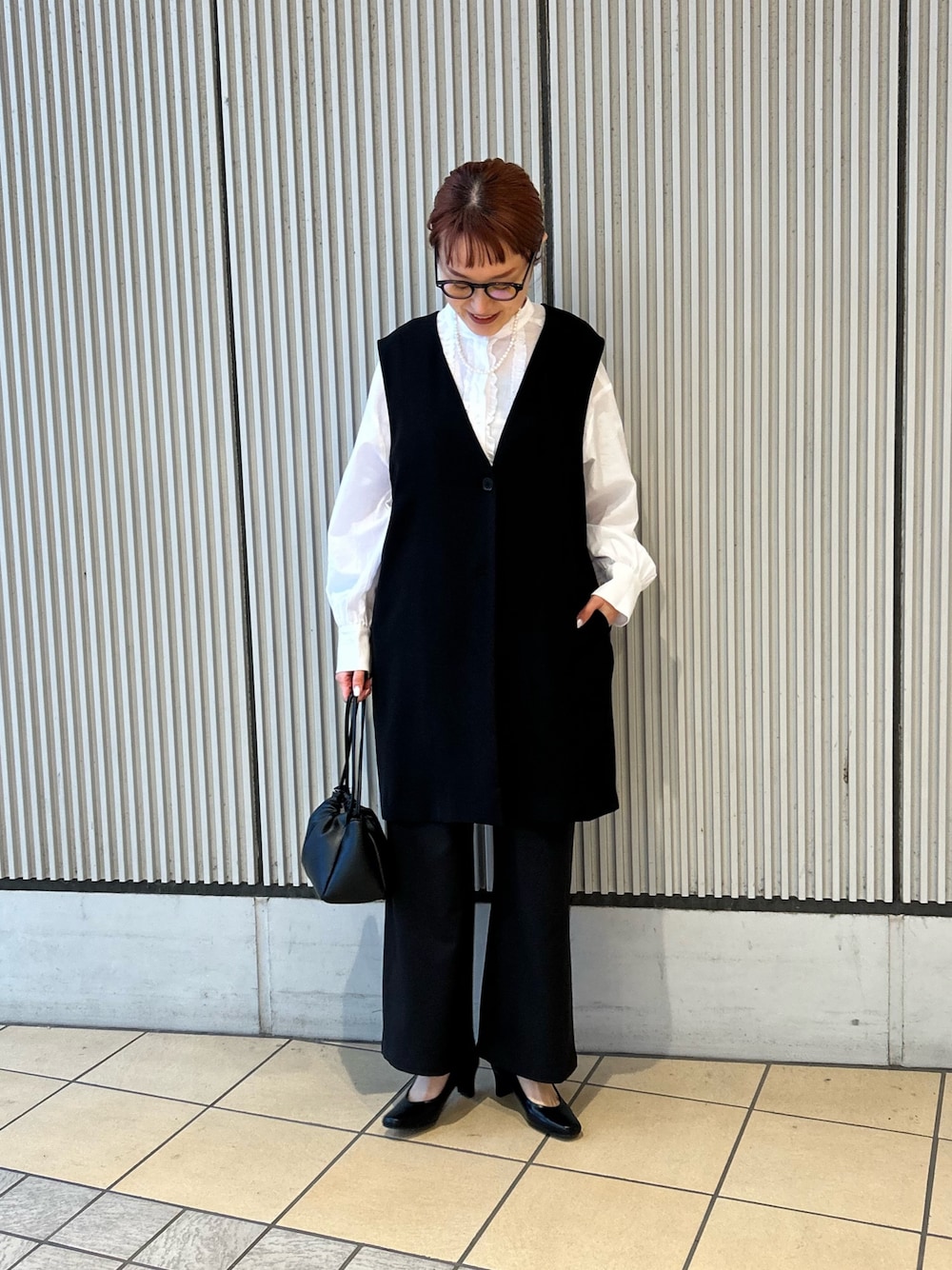 ブラック系のベスト、ブラック系のその他パンツ、ブラック系のパンプスを着用したレディースの冬コーディネートの1枚目の写真
