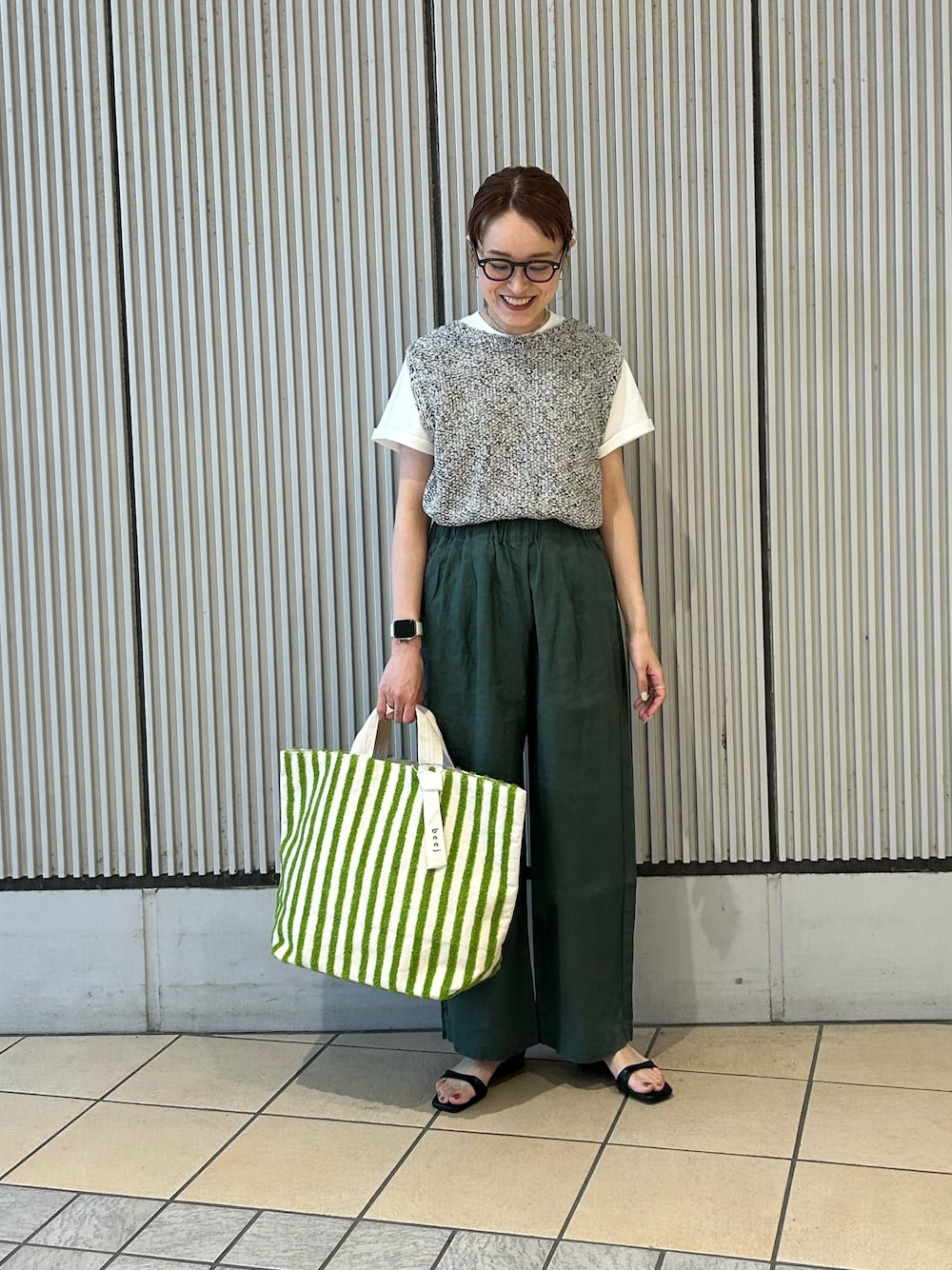 グリーン系のその他パンツ、グレー系のニット/セーター、ホワイト系のTシャツ/カットソーを着用したレディースの春コーディネートの1枚目の写真
