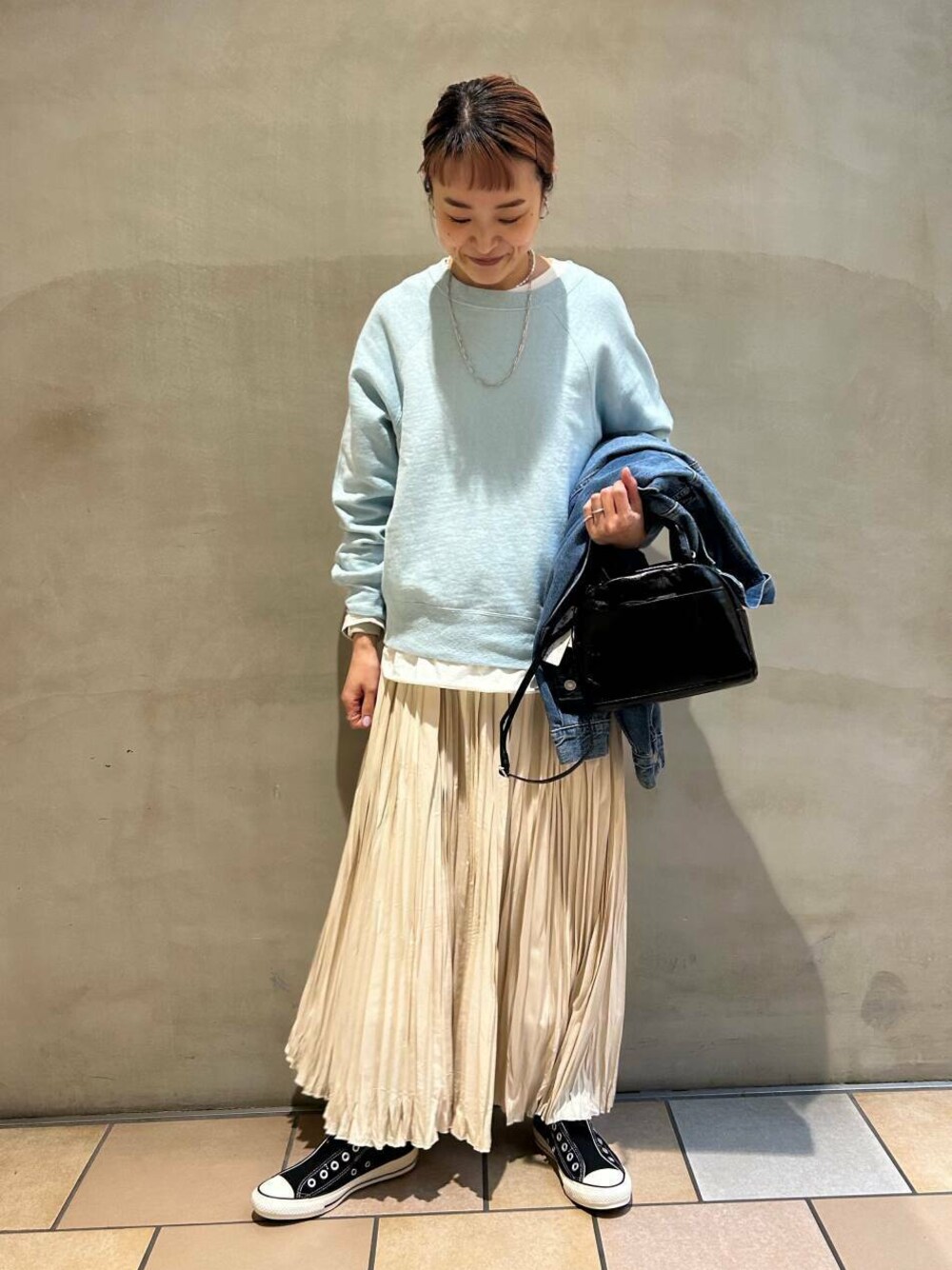 ブラック系のショルダーバッグ、ホワイト系のTシャツ/カットソー、ブルー系のスウェットを着用したレディースの冬コーディネートの1枚目の写真