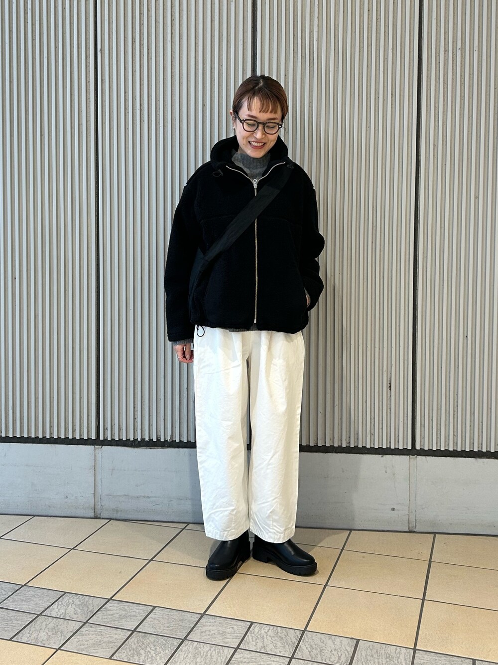 ブラック系のブルゾン、ホワイト系のその他パンツ、ブラック系のブーツを着用したレディースの冬コーディネートの1枚目の写真