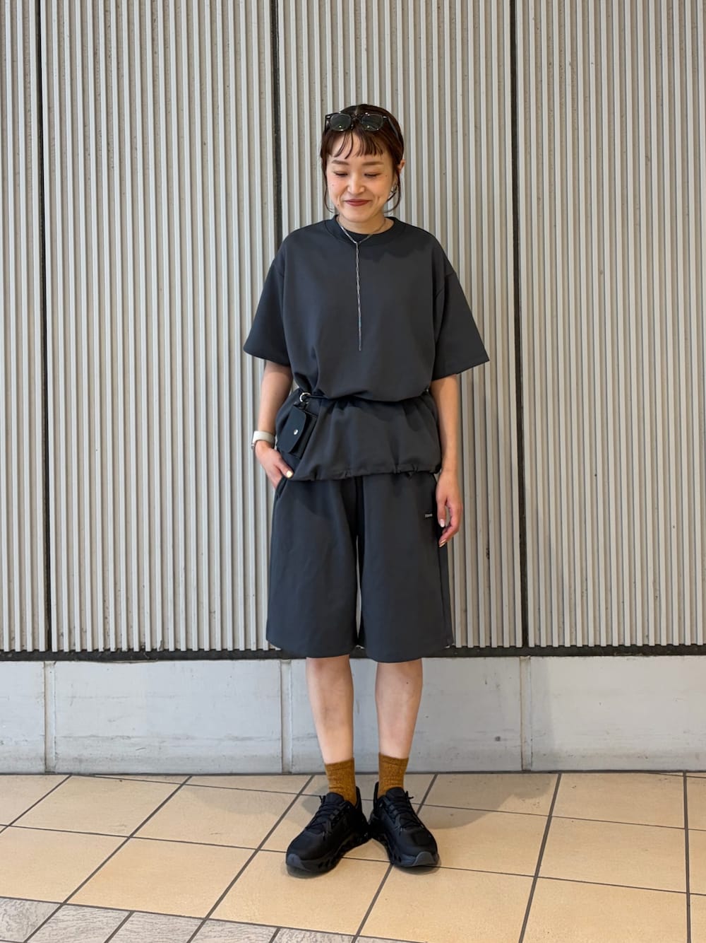 ブラック系のスニーカー、グレー系のルームウェア/パジャマ、ブラック系のポーチを着用したレディースの夏コーディネートの1枚目の写真