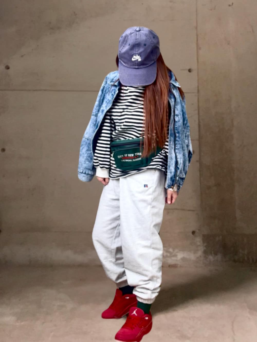 グレー系のスウェットパンツ、ブルー系のデニムジャケット、グリーン系のボディバッグ/ウエストポーチを着用したレディースの冬コーディネートの1枚目の写真