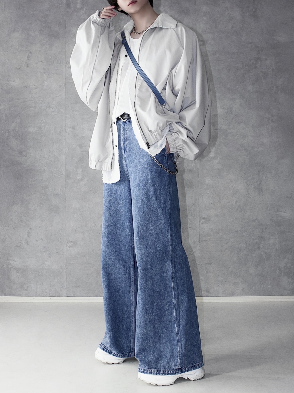 ブルー系のデニムパンツ、ホワイト系のスニーカー、ホワイト系のブルゾンを着用したメンズの春コーディネートの1枚目の写真