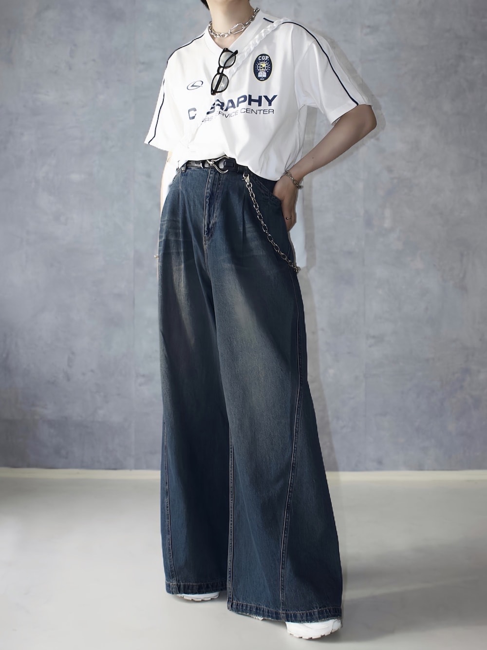 ブルー系のデニムパンツ、ホワイト系のTシャツ/カットソー、ホワイト系のスニーカーを着用したメンズの夏コーディネートの1枚目の写真