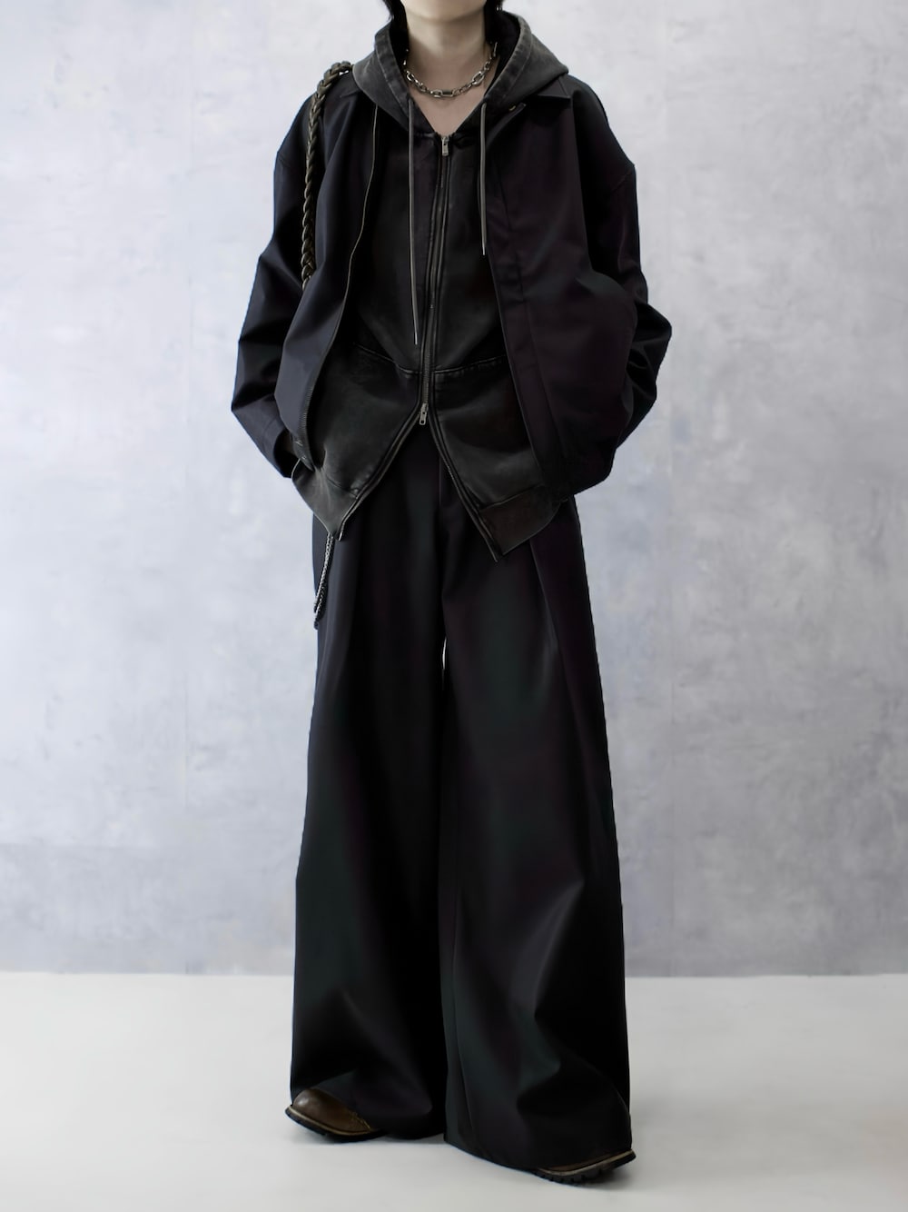 ブラウン系のパーカー、ブラック系のブーツ、ブラック系のブルゾンを着用したメンズの秋コーディネートの1枚目の写真