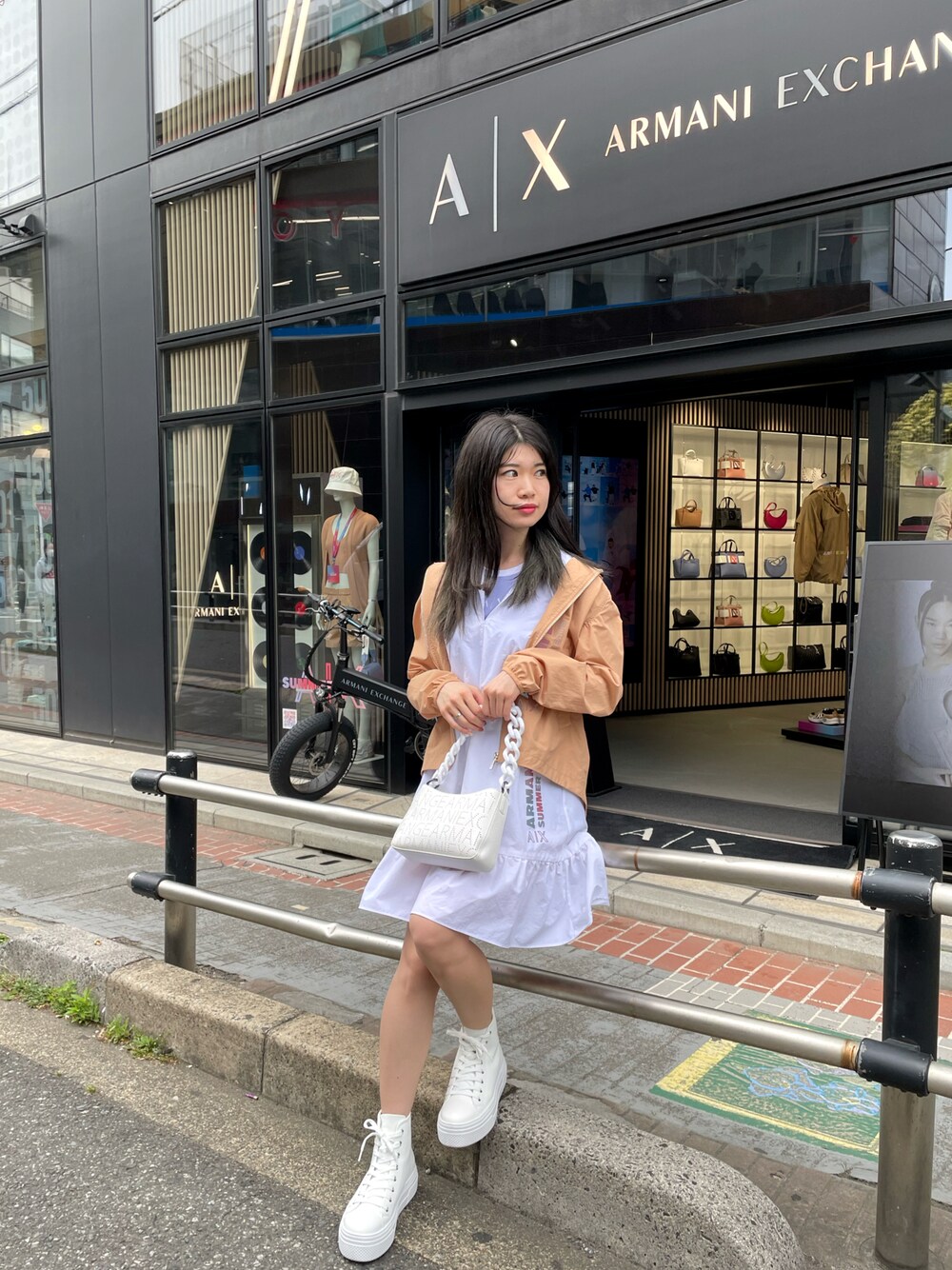 ホワイト系のワンピース、ホワイト系のショルダーバッグ、ブルー系のタンクトップを着用したレディースの春コーディネートの1枚目の写真