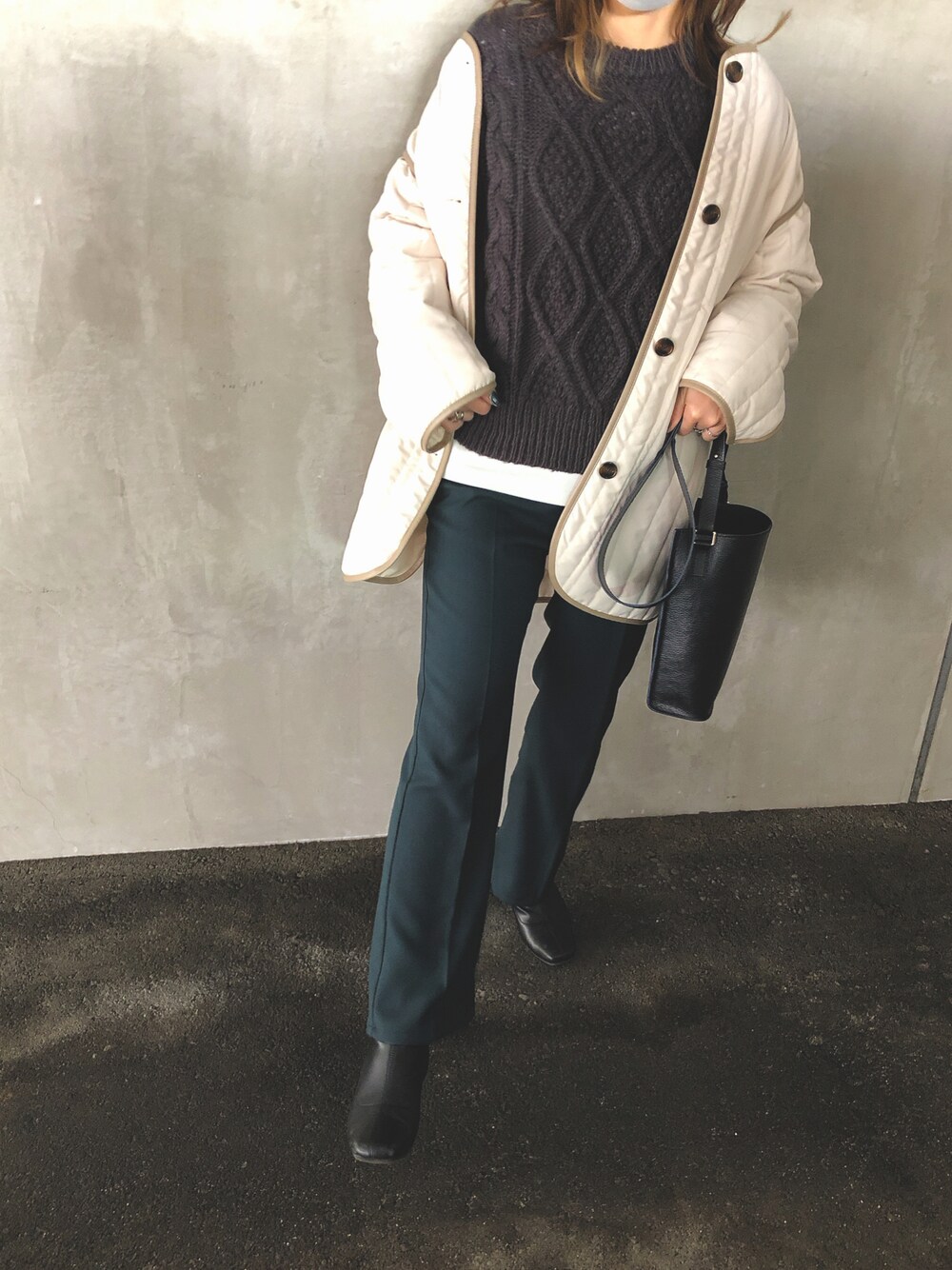 グリーン系のスラックス、ブラック系のブーツ、ブラック系のショルダーバッグを着用したレディースの冬コーディネートの1枚目の写真