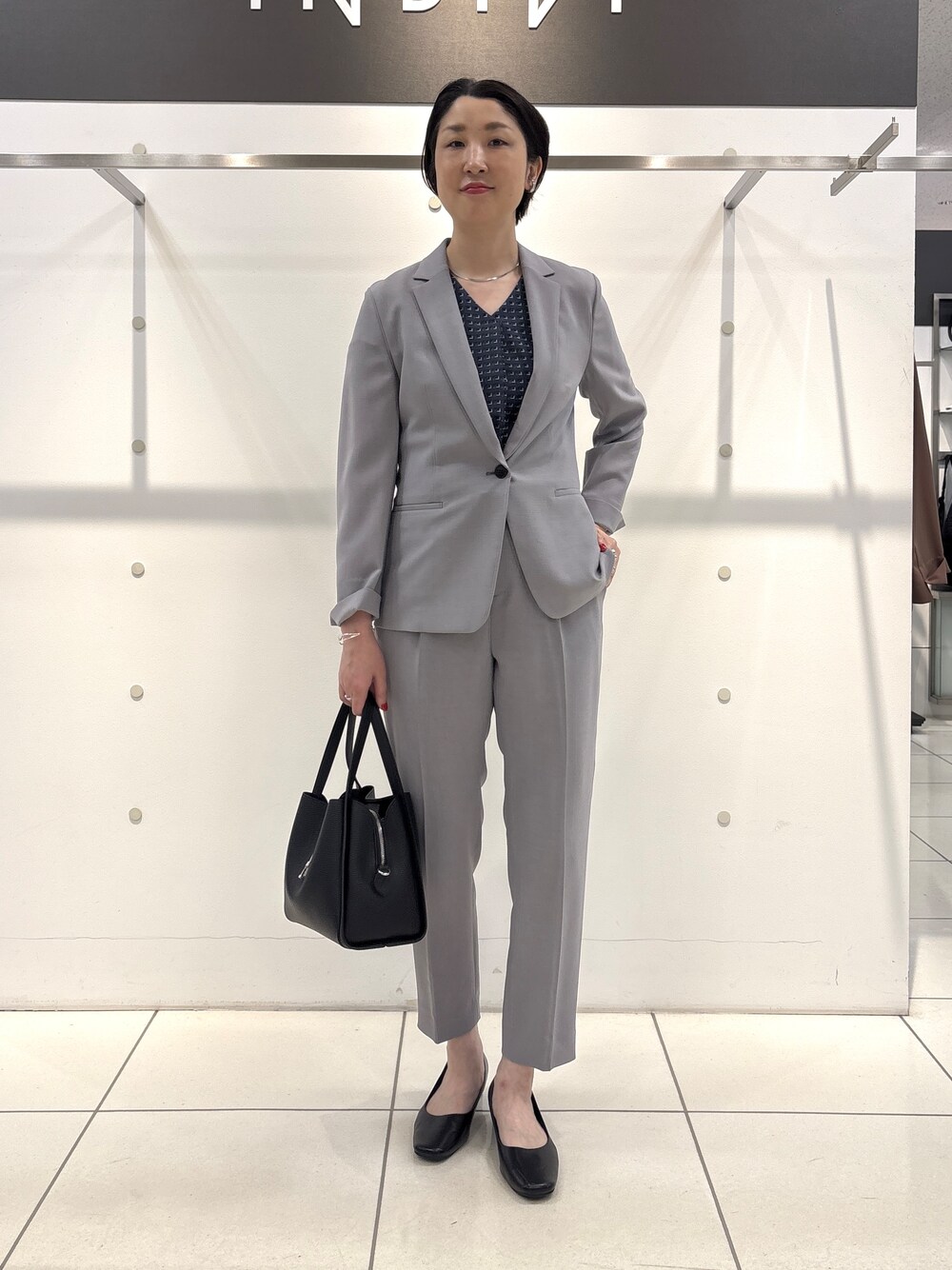 グレー系のスーツジャケット、グレー系のシャツ/ブラウス、グレー系のスーツパンツを着用したレディースの夏コーディネートの1枚目の写真