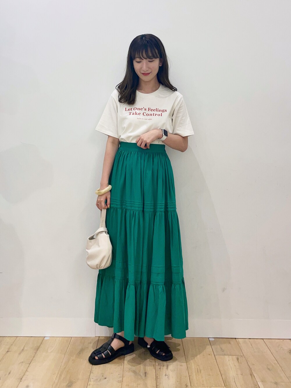 その他のTシャツ/カットソー、グリーン系のスカート、ホワイト系のハンドバッグを着用したレディースの夏コーディネートの1枚目の写真