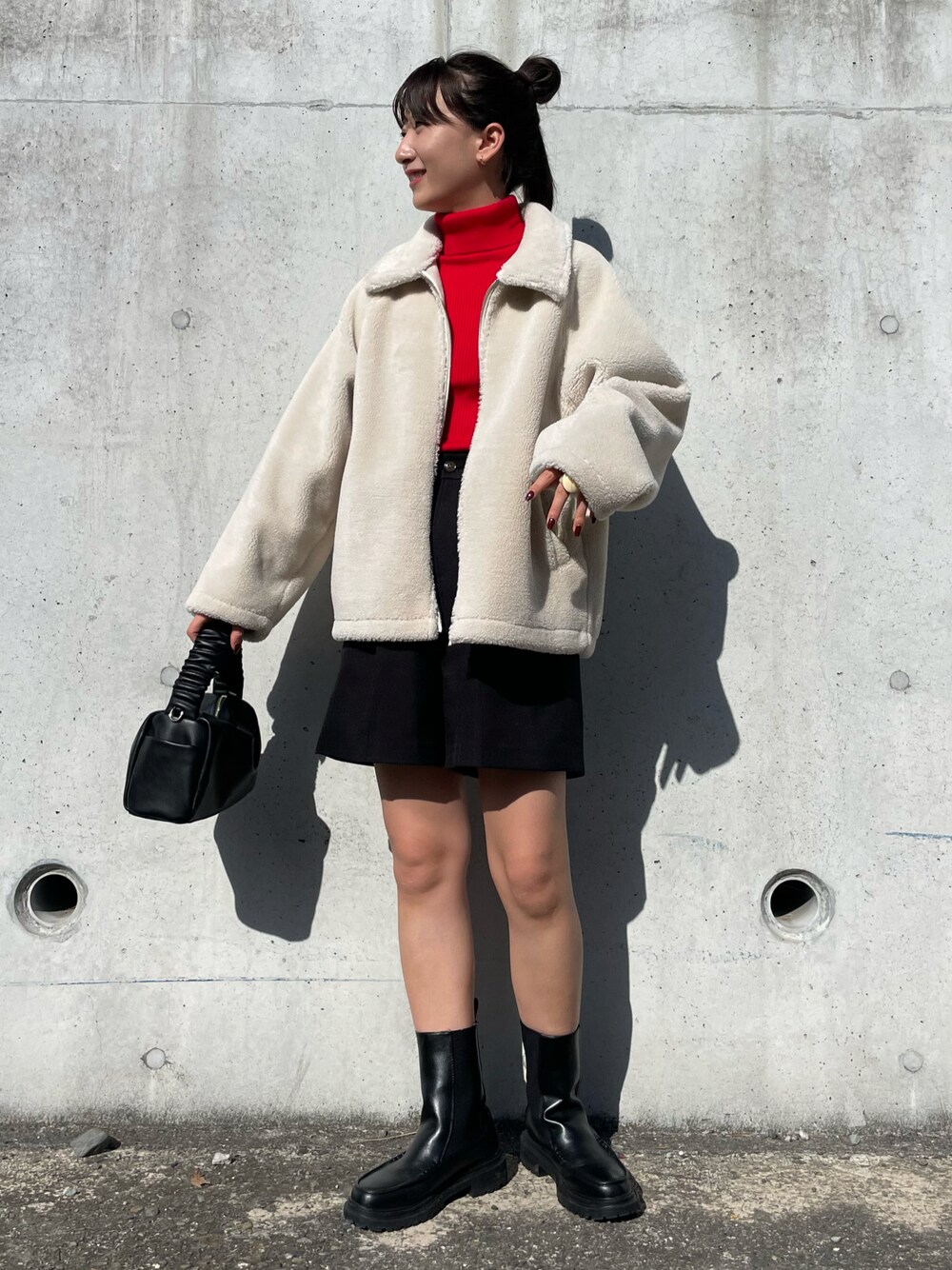 レッド系のニット/セーター、ホワイト系のブルゾン、ブラック系のスラックスを着用したレディースの秋コーディネートの1枚目の写真
