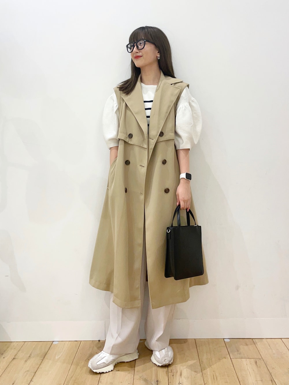 ホワイト系のニット/セーター、ベージュ系のトレンチコート、ホワイト系のスニーカーを着用したレディースの春コーディネートの1枚目の写真