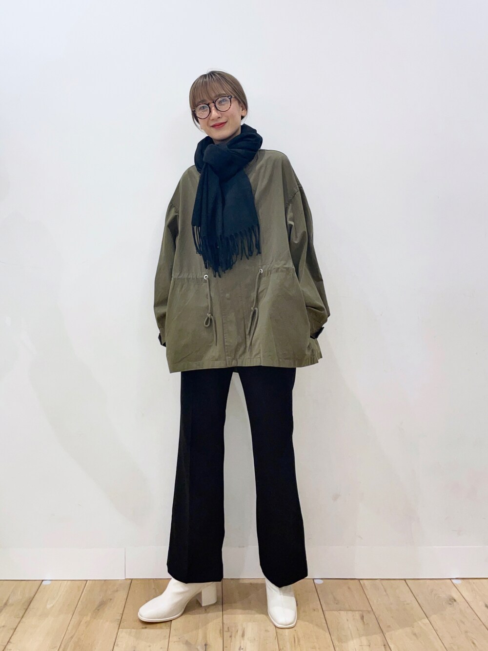 ホワイト系のブーツ、ブラック系のその他パンツ、グリーン系のミリタリージャケットを着用したレディースの冬コーディネートの1枚目の写真