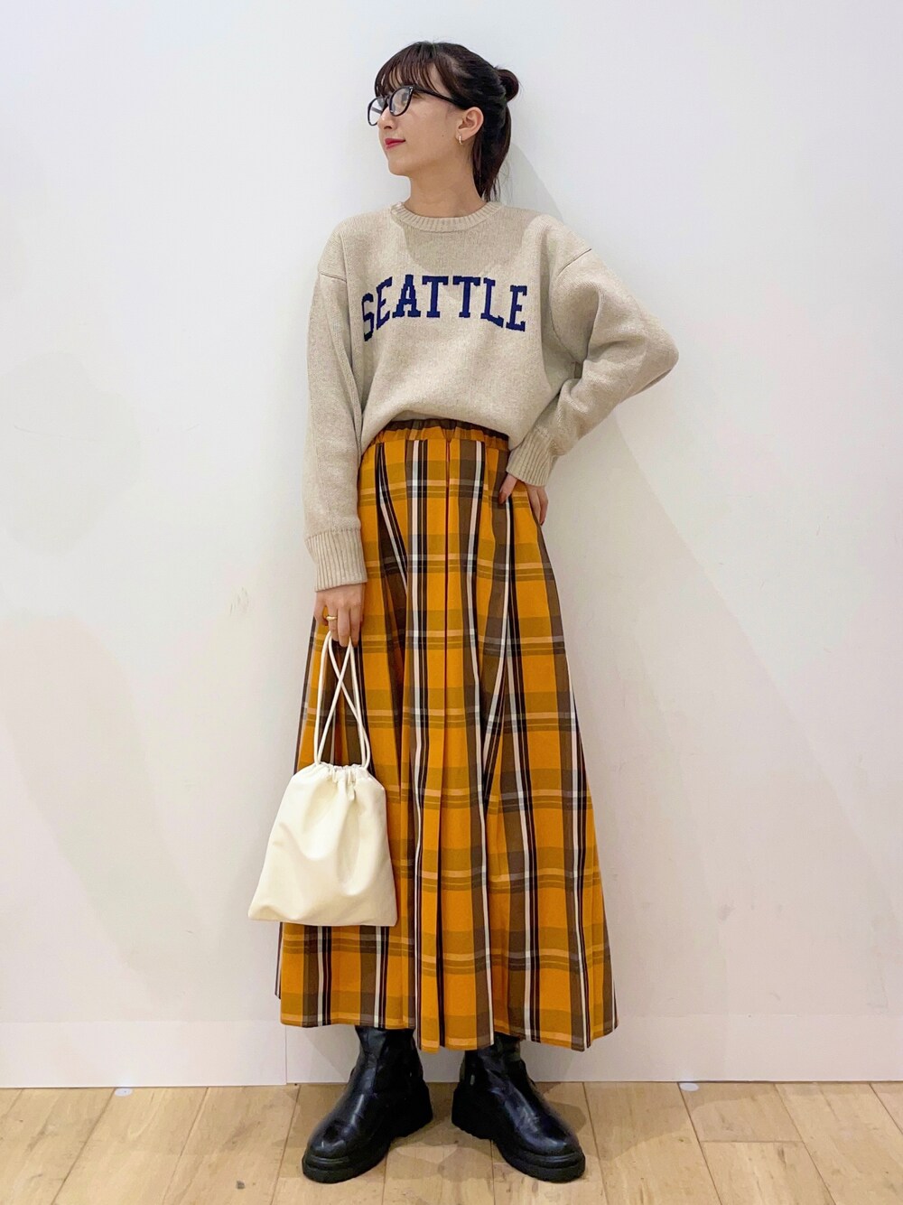 ベージュ系のニット/セーター、ベージュ系のショルダーバッグ、ブラック系のブーツを着用したレディースの秋コーディネートの1枚目の写真