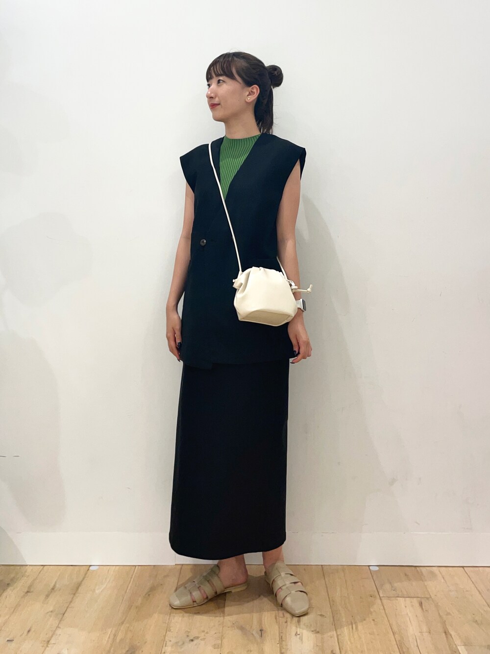 ブラック系のその他アウター、ブラック系のスカート、グリーン系のニット/セーターを着用したレディースの夏コーディネートの1枚目の写真