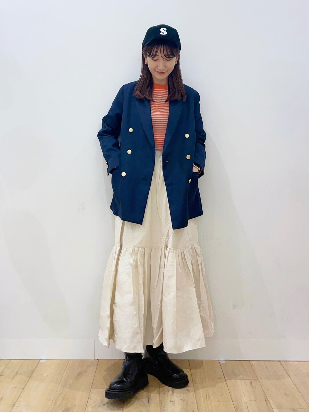 ホワイト系のスカート、ブルー系のその他アウター、オレンジ系のTシャツ/カットソーを着用したレディースの秋コーディネートの1枚目の写真