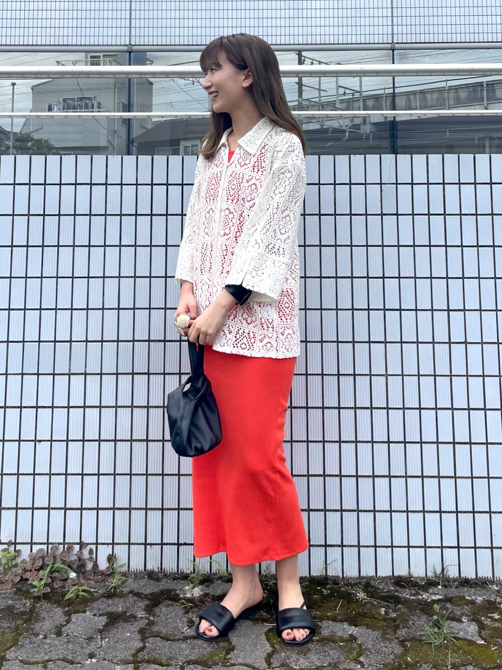 ブラック系のサンダル、ホワイト系のシャツ/ブラウス、ブラック系のハンドバッグを着用したレディースの夏コーディネートの1枚目の写真