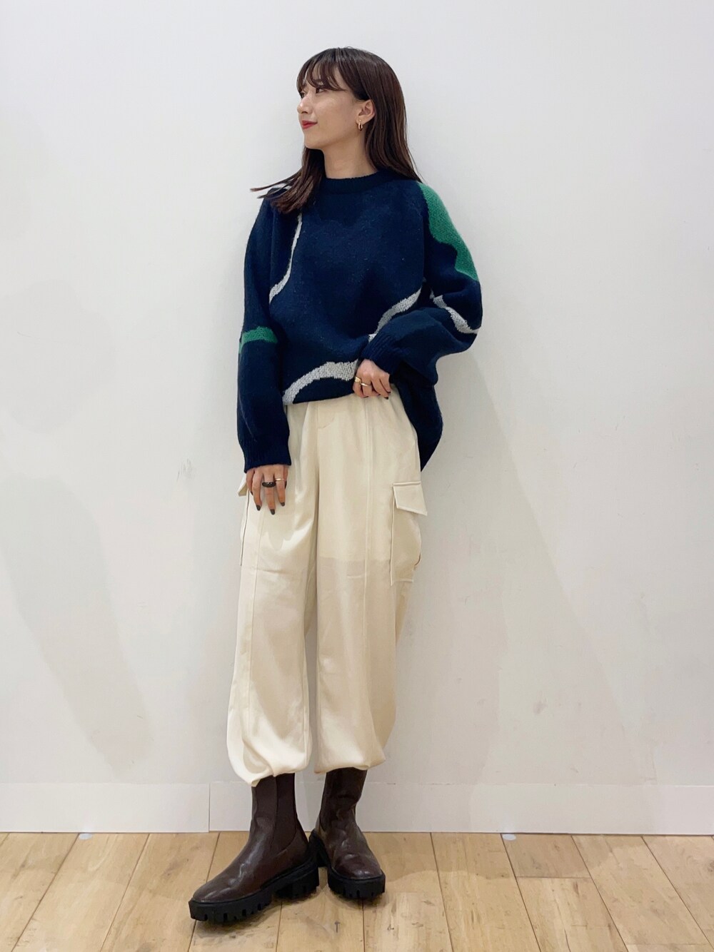 ブルー系のニット/セーター、ホワイト系のその他パンツ、ブラウン系のブーツを着用したレディースの秋コーディネートの1枚目の写真