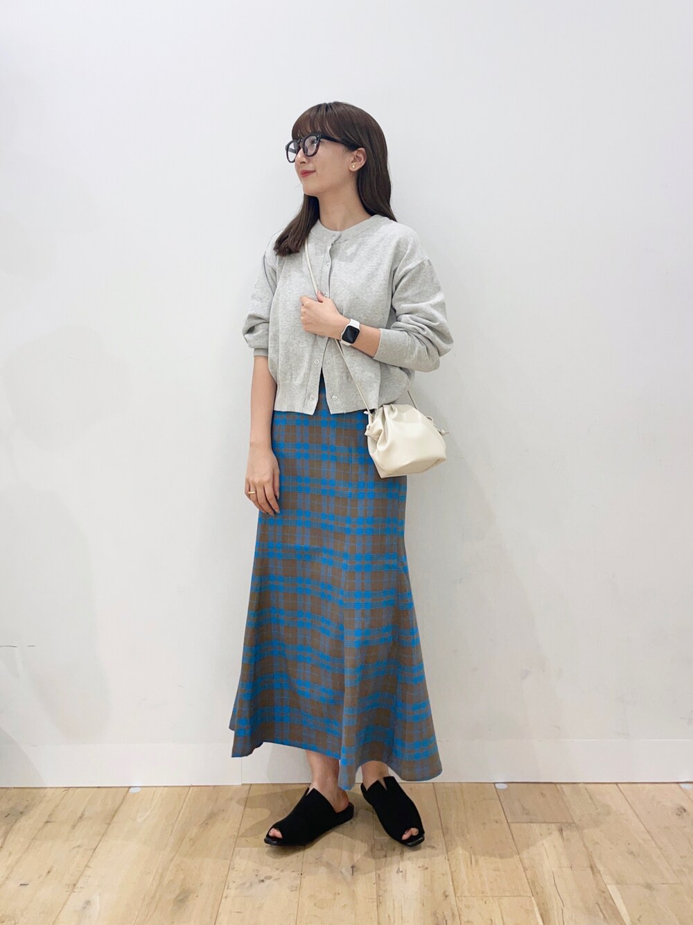 ベージュ系のカーディガン/ボレロ、ホワイト系のショルダーバッグ、ブラック系のサンダルを着用したレディースの夏コーディネートの1枚目の写真