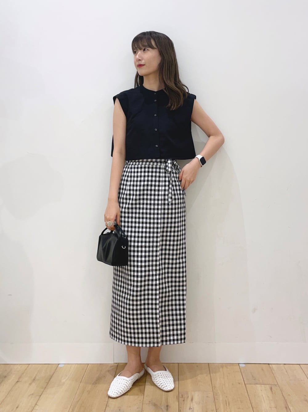 ブラック系のシャツ/ブラウス、ブラック系のスカート、ブラック系のショルダーバッグを着用したレディースの春コーディネートの1枚目の写真