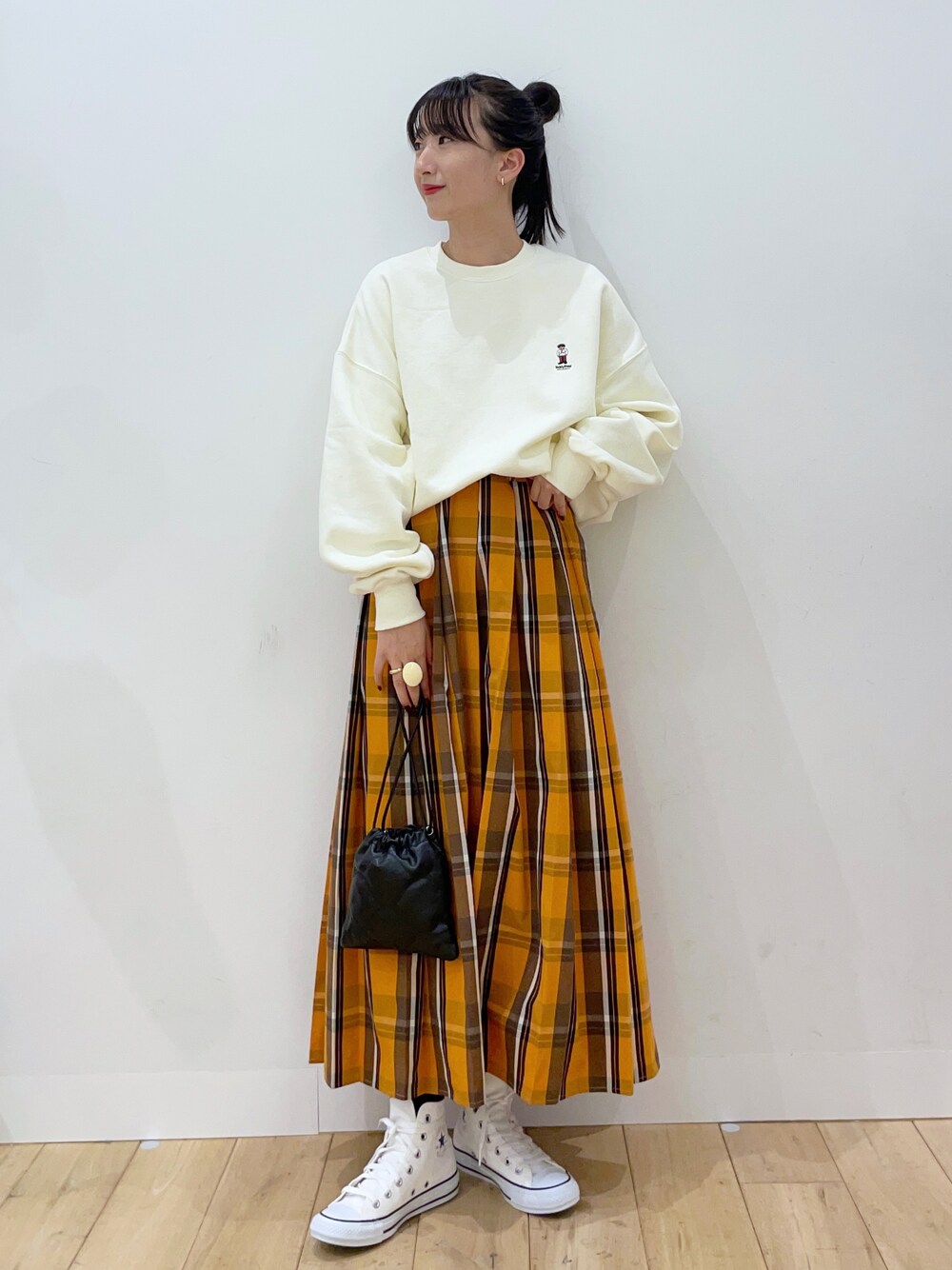 ベージュ系のスウェット、オレンジ系のスカート、ホワイト系のスニーカーを着用したレディースの秋コーディネートの1枚目の写真