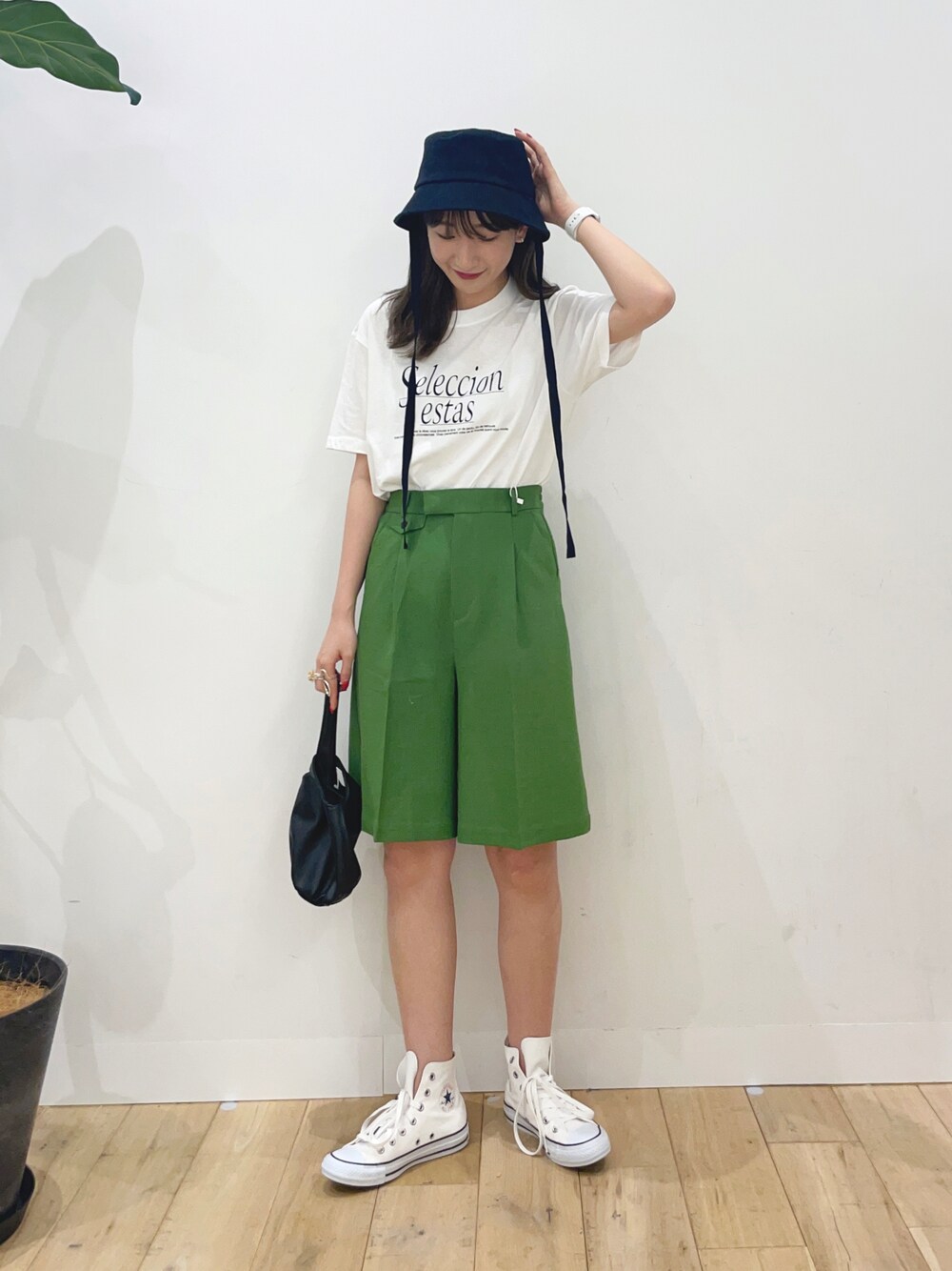 グリーン系のその他パンツ、ホワイト系のスニーカー、ブラック系のハンドバッグを着用したレディースの春コーディネートの1枚目の写真