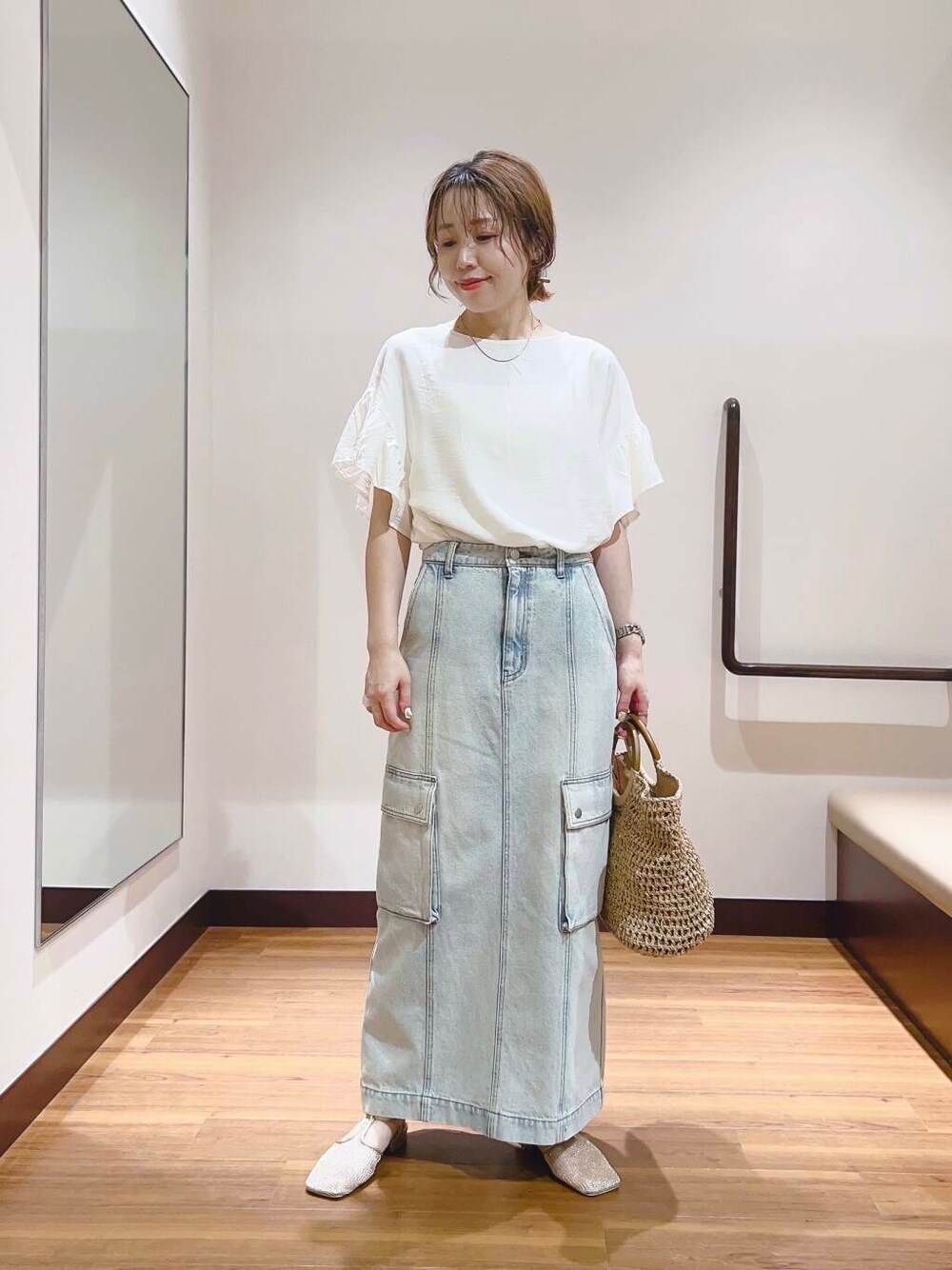 ゴールド系のサンダル、ベージュ系のトートバッグ、ブルー系のスカートを着用したレディースの夏コーディネートの1枚目の写真