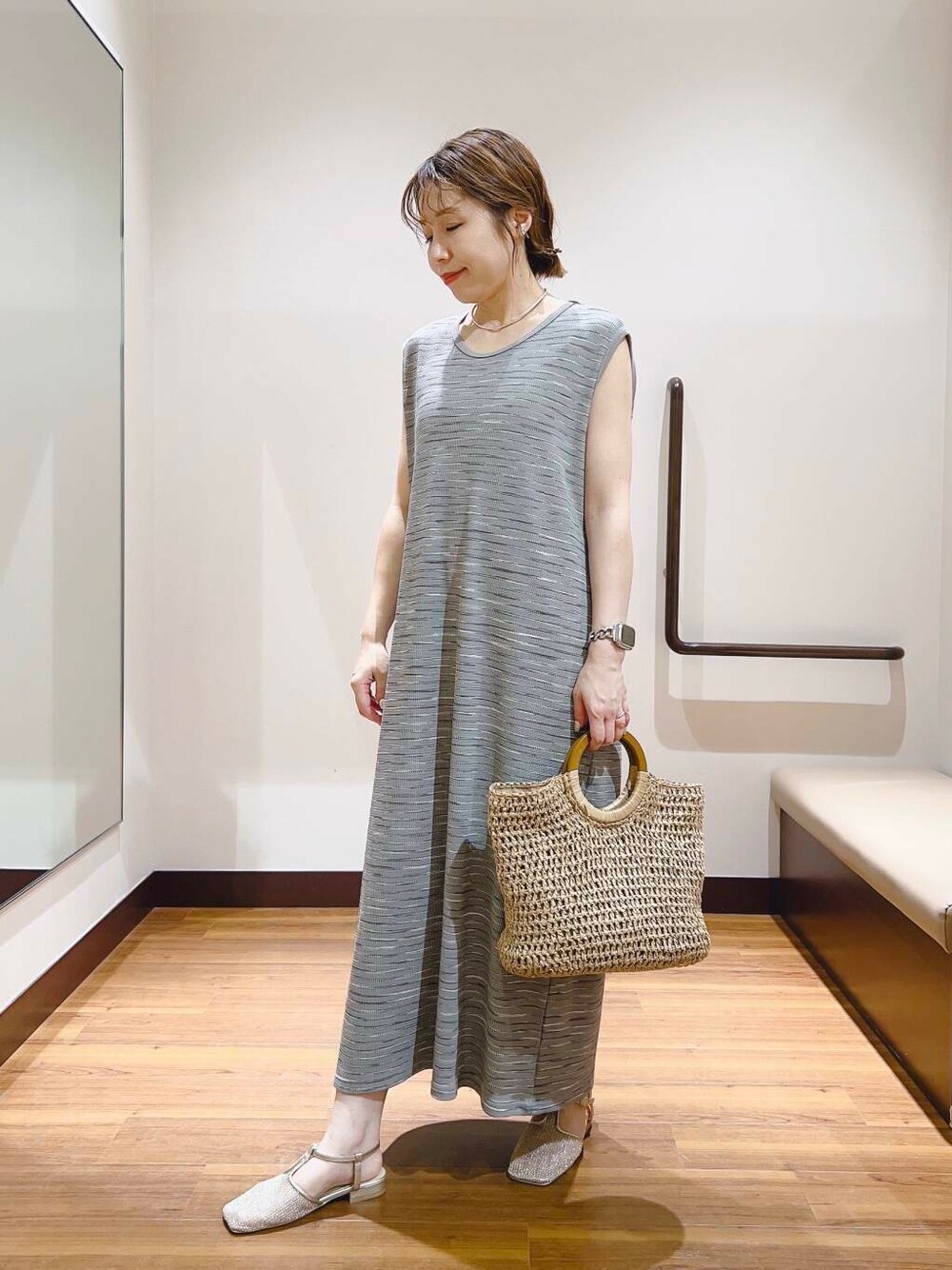ベージュ系のトートバッグ、グレー系のワンピースを着用したレディースの夏コーディネートの1枚目の写真