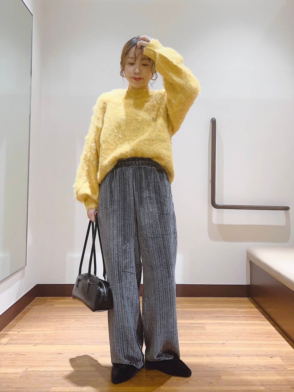 イエロー系のニット/セーター、ブラック系のその他シューズ、グレー系のその他パンツを着用したレディースの秋コーディネートの1枚目の写真