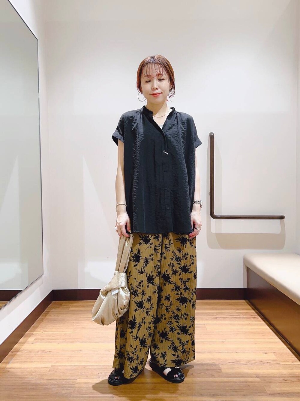 ゴールド系のハンドバッグ、ブラウン系のその他パンツを着用したレディースの夏コーディネートの1枚目の写真