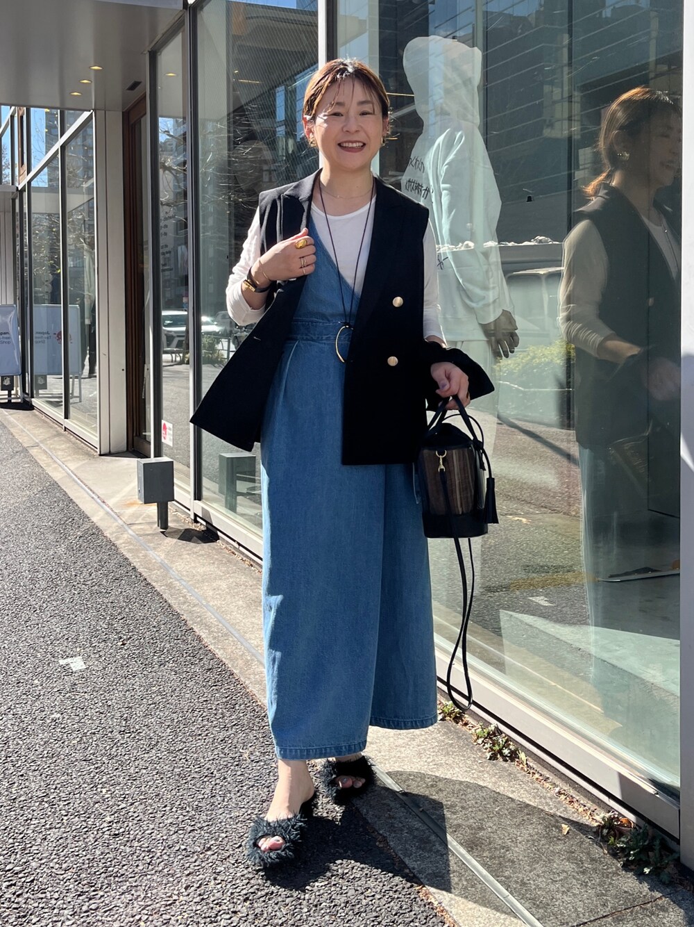 ブラック系のベスト、ホワイト系のTシャツ/カットソー、ブルー系のワンピースを着用したレディースの冬コーディネートの1枚目の写真