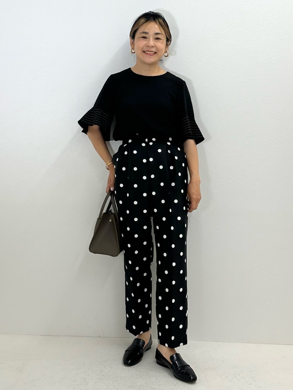 ブラック系のシャツ/ブラウス、ブラック系のその他パンツ、ベージュ系のトートバッグを着用したレディースの夏コーディネートの1枚目の写真