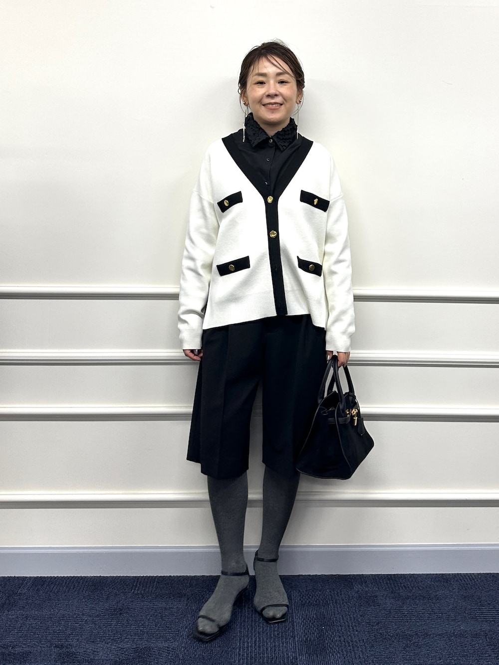 ホワイト系のカーディガン/ボレロ、ブラック系のシャツ/ブラウス、ブラック系のトートバッグを着用したレディースの冬コーディネートの1枚目の写真