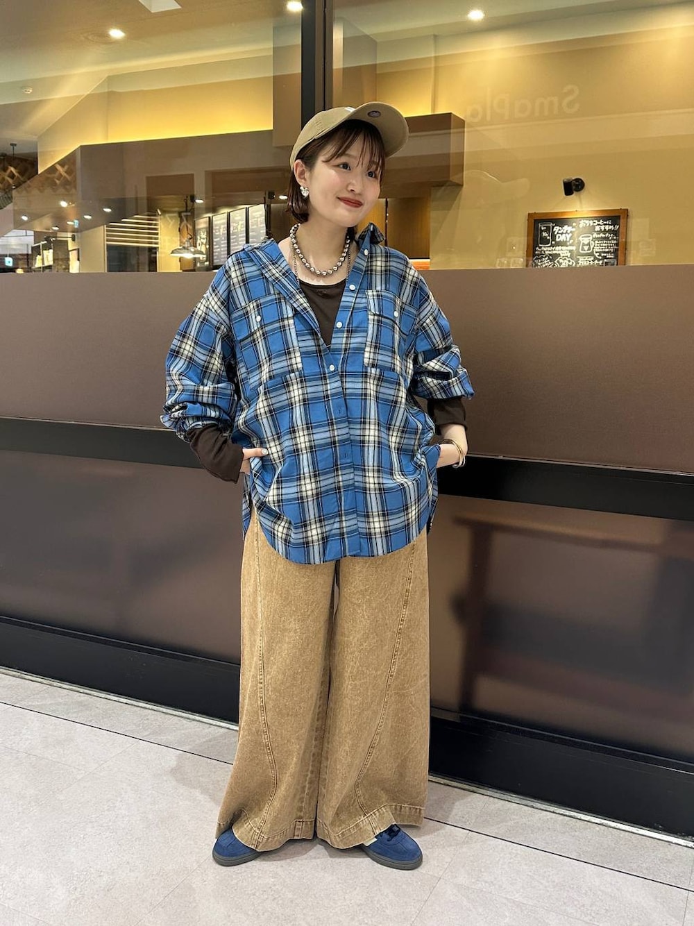 ブラウン系のデニムパンツ、ブルー系のシャツ/ブラウス、ブラウン系のTシャツ/カットソーを着用したレディースの夏コーディネートの1枚目の写真