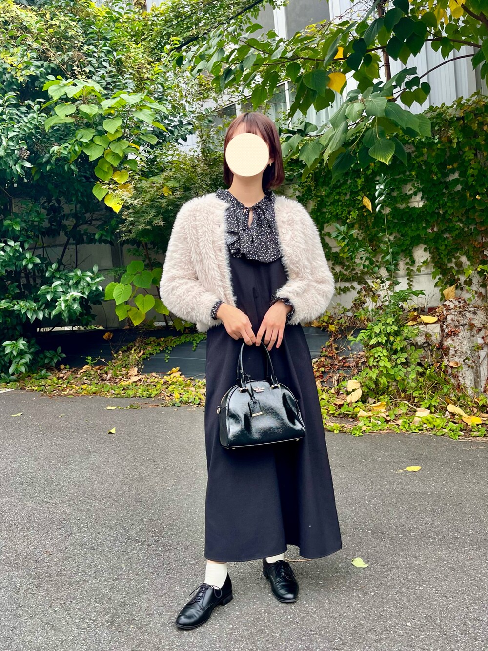 ブラック系のトートバッグ、ベージュ系のカーディガン/ボレロ、ブラック系のシャツ/ブラウスを着用したレディースの秋コーディネートの1枚目の写真