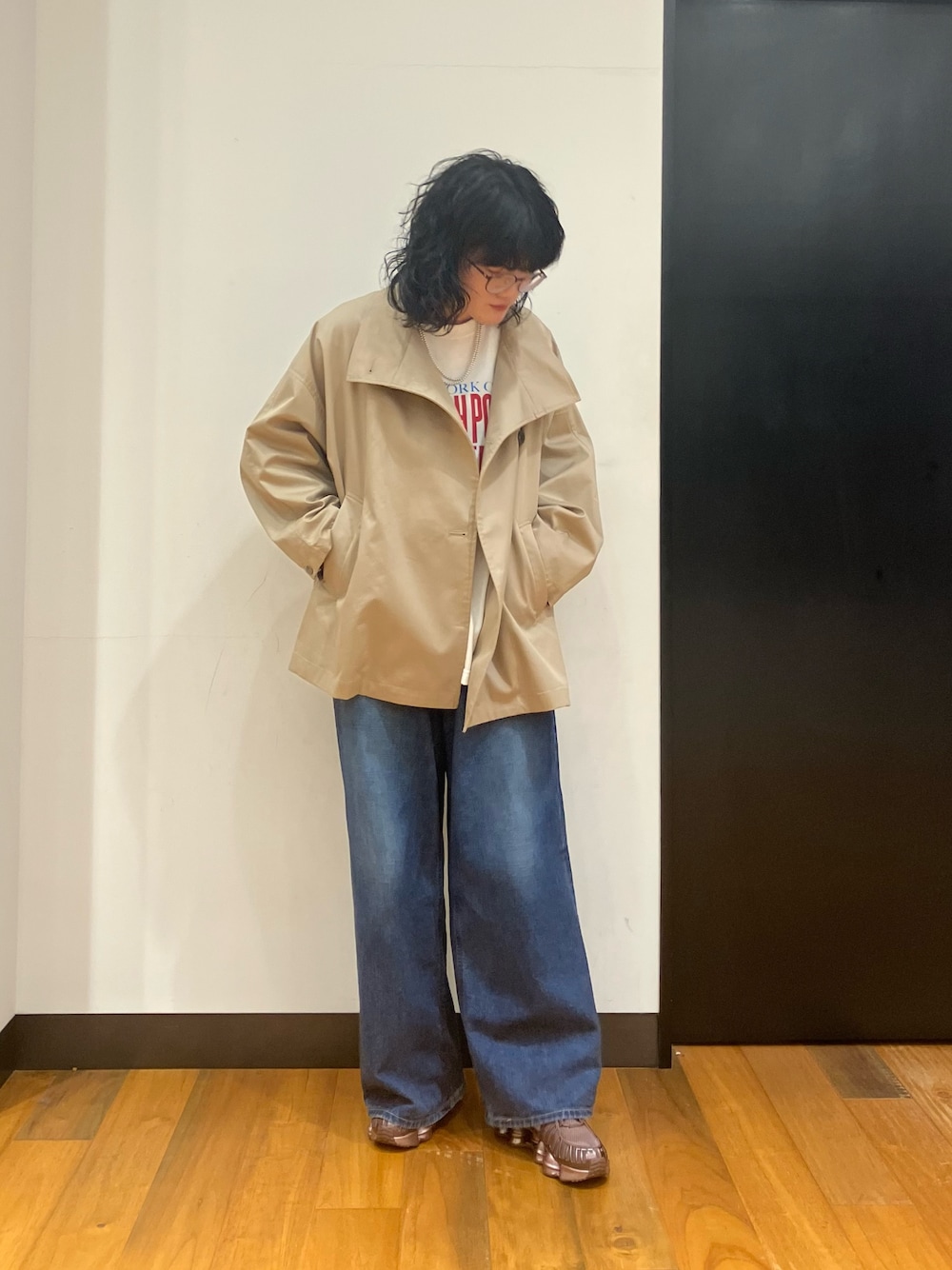 ホワイト系のTシャツ/カットソー、ベージュ系のトレンチコート、ブルー系のデニムパンツを着用したレディースの冬コーディネートの1枚目の写真