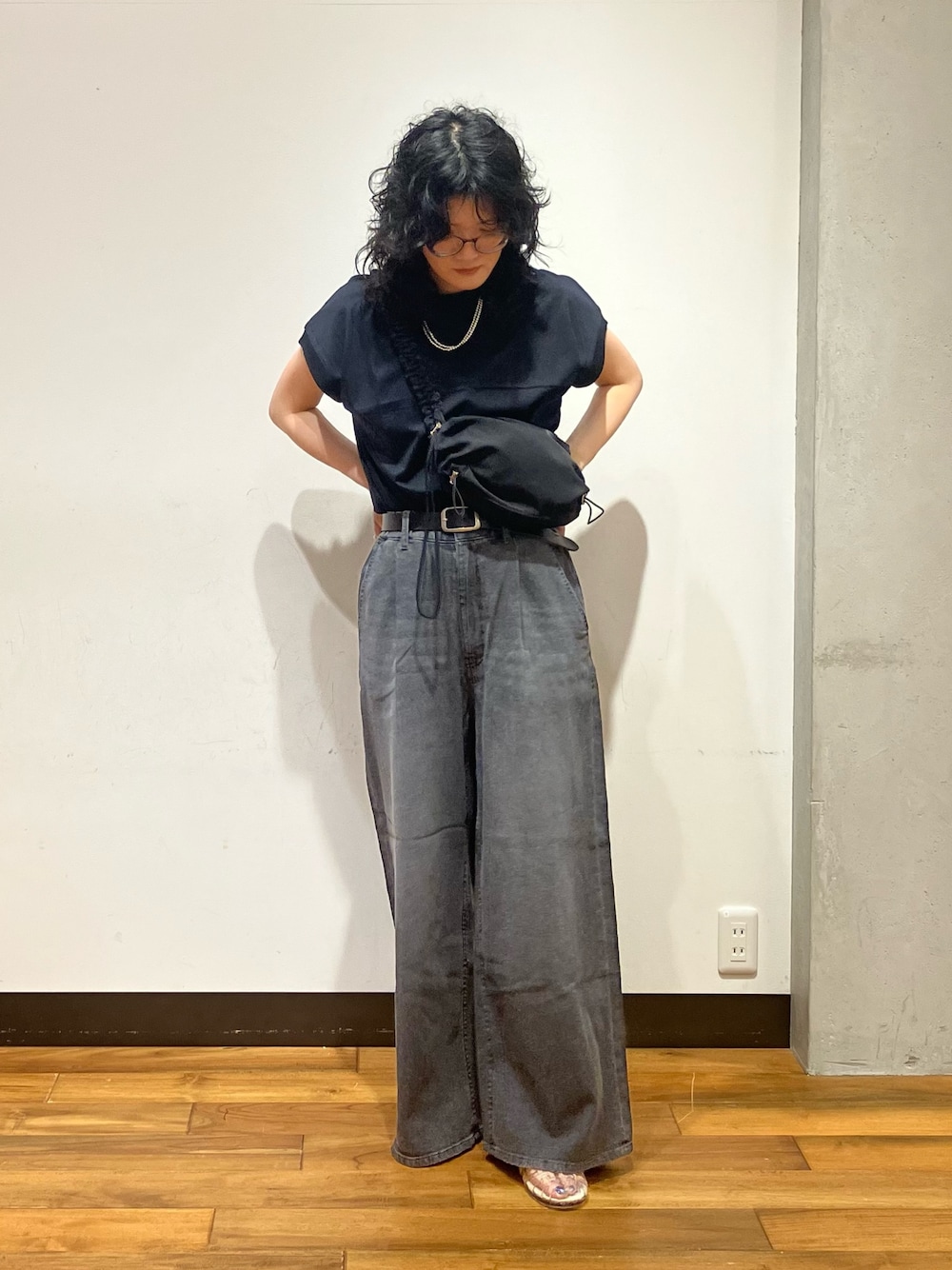 ブラック系のデニムパンツ、その他のサンダル、ブラック系のショルダーバッグを着用したレディースの夏コーディネートの1枚目の写真